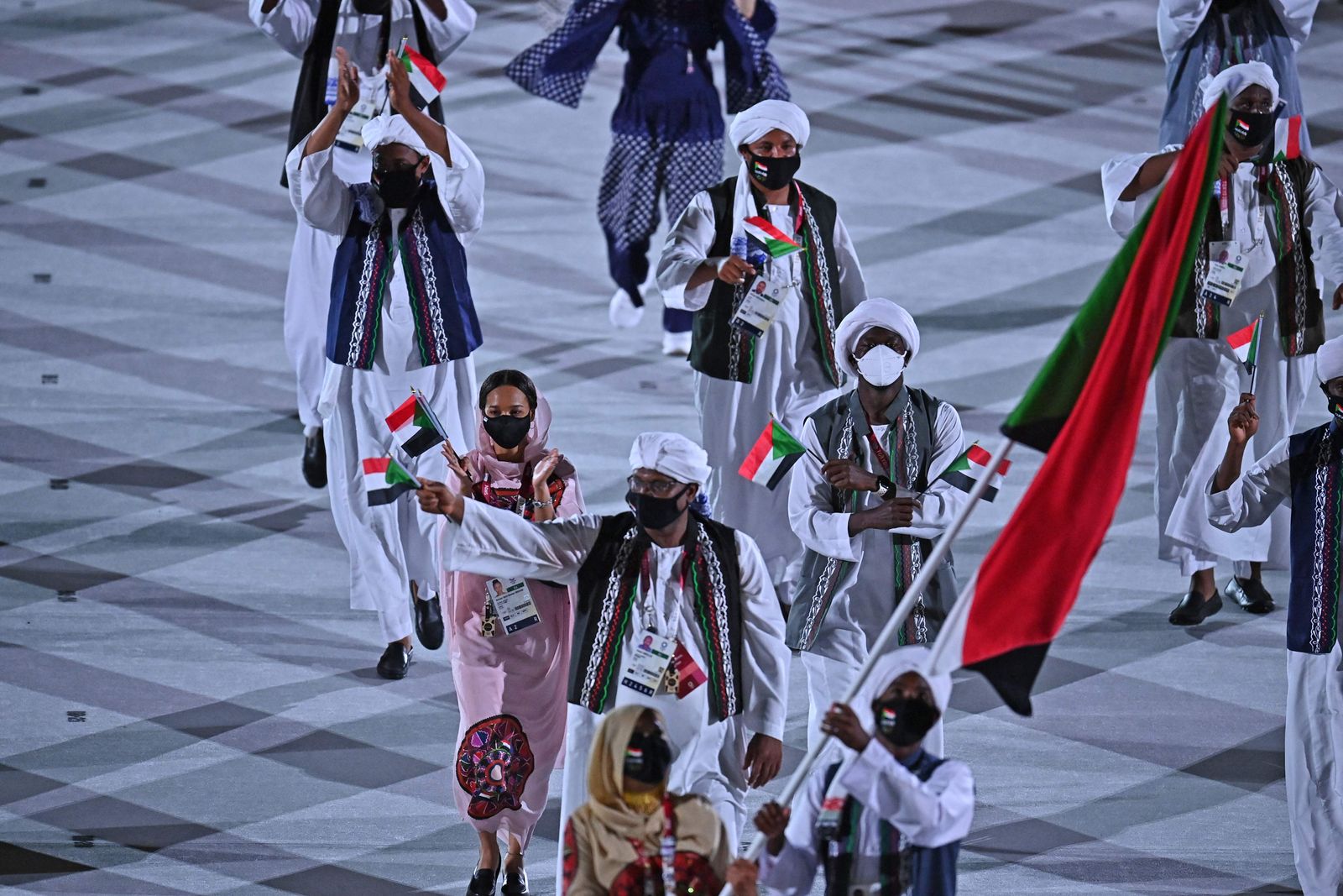 Sudan's flag bearer Esraa Mohamed Ahmed Mohamed  and Sudan's flag bearer Abobakr Abass lead the delegation during the opening ceremony of the Tokyo 2020 Olympic Games, at the Olympic Stadium, in Tokyo, on July 23, 2021. (Photo by Ben STANSALL / AFP) - AFP