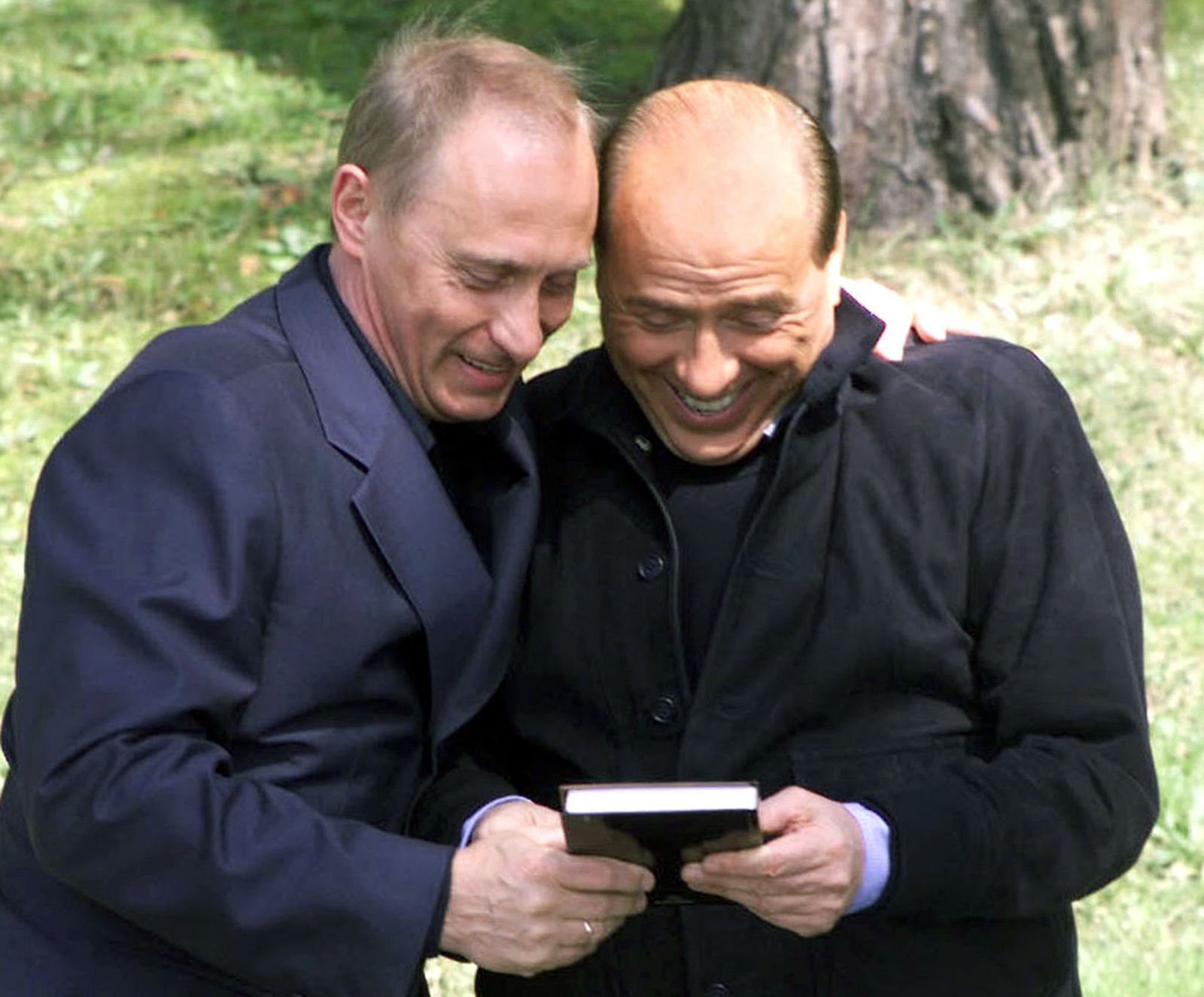 الرئيس الروسي فلاديمير بوتين يقدّم لرئيس الوزراء الإيطالي السابق سيلفيو برلوسكوني كتاباً روسياً عن الحياة السياسية للأخير، خلال لقائهما في منتجع سوتشي على البحر الأسود - 2 أبريل 2002 - REUTERS