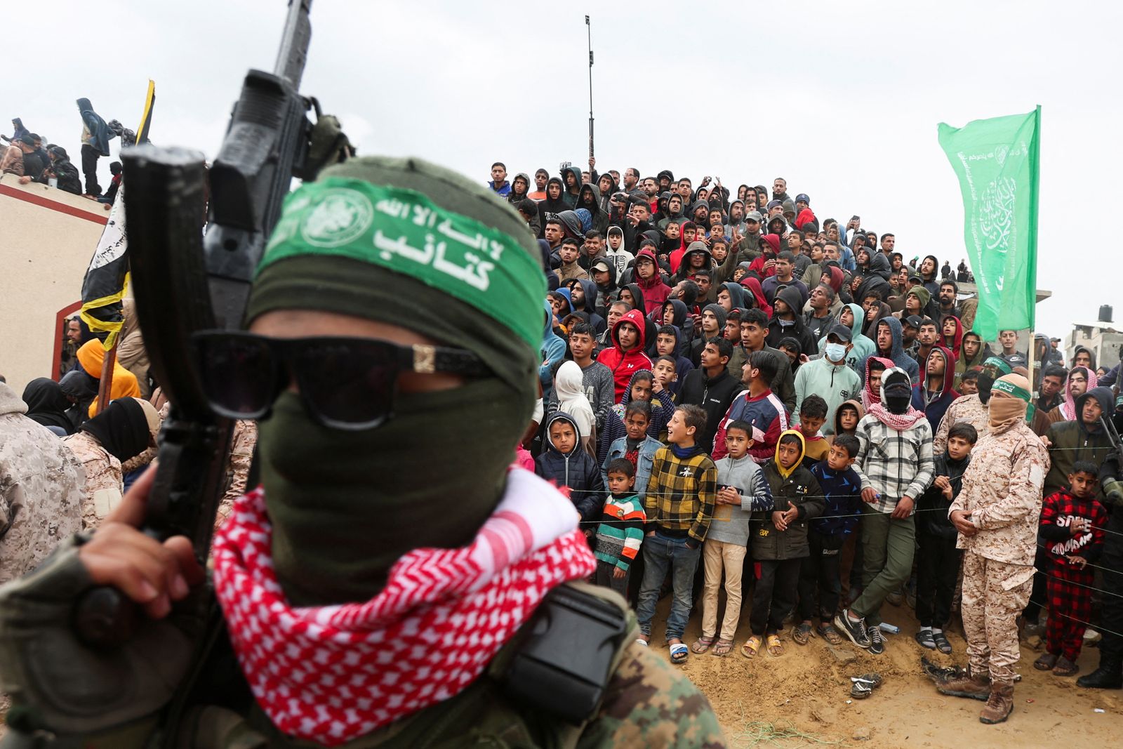 Palestinians look on during the handover by Hamas of deceased hostages Oded Lifschitz, Shiri Bibas and her two children Kfir and Ariel Bibas, seized during the deadly October 7, 2023 attack, to the Red Cross, as part of a ceasefire and hostages-prisoners swap deal between Hamas and Israel, in Khan Younis in the southern Gaza Strip, February 20, 2025. REUTERS/Ramadan Abed