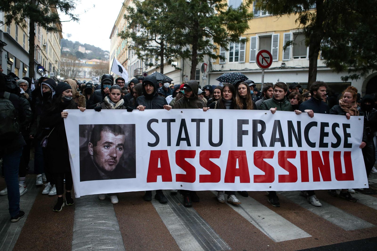 Demonstrators hold a banner as they take part in a protest a week after nationalist figure Yvan Colonna was attacked in prison, in Bastia, on the French Mediterranean island of Corsica, on March 13, 2022. - The Corsican nationalist, who is serving a life sentence for the assassination in 1998 of Corsica's top regional official Claude Erignac, is in a coma after being beaten on March 2 in jail by a fellow detainee, according to investigators. (Photo by Pascal POCHARD-CASABIANCA / AFP) - AFP