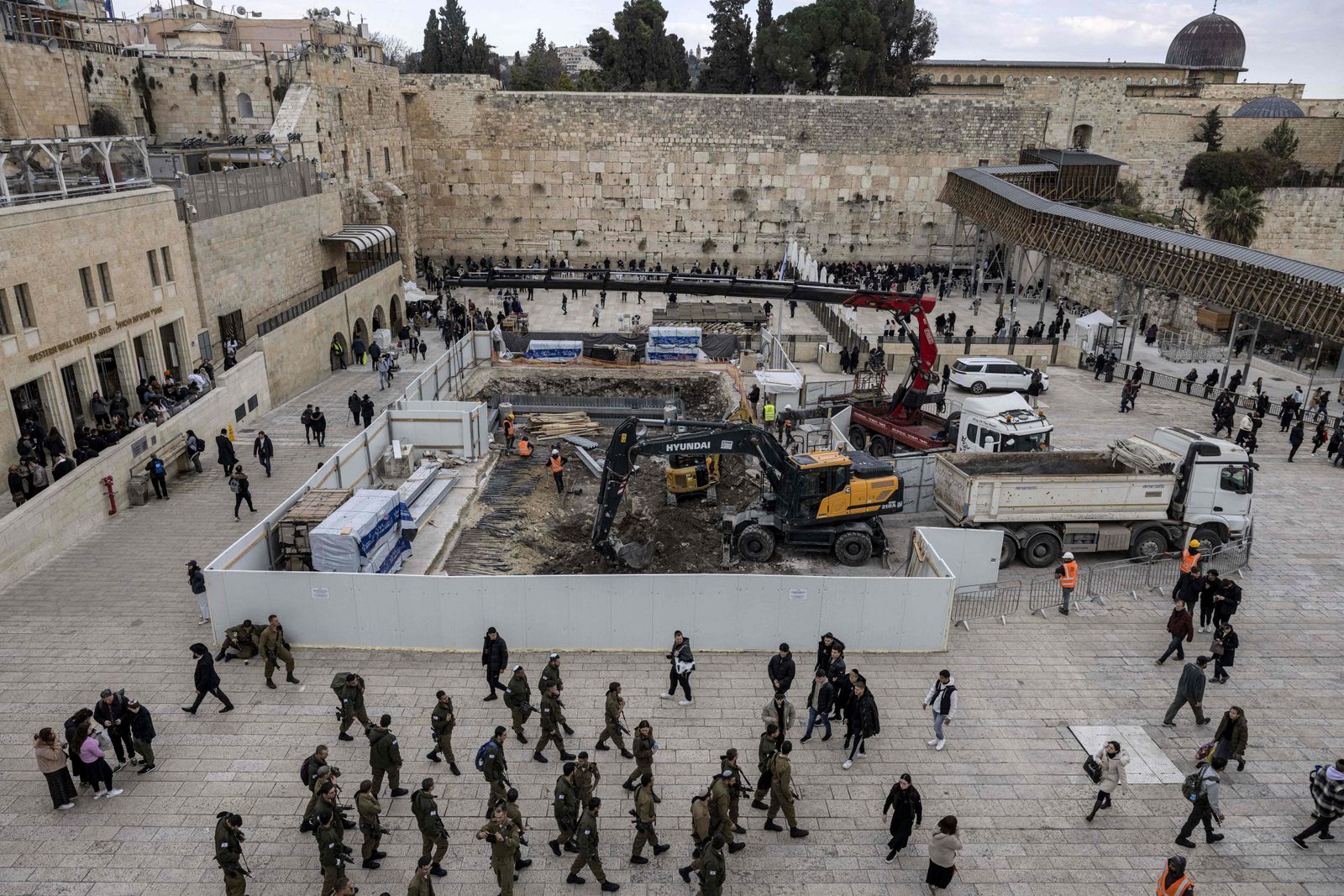(FILES) This file photo taken on January 15, 2023 shows a view of construction works conducted by the Western Wall Heritage Foundation to build an underground floor at the Plaza of the Western Wall (C), the holiest site where Jews are allowed to pray, in the Old City of Jerusalem, with the al-Aqsa Mosque complex seen in the background. - At Jerusalem's Western Wall plaza, a recent excavation has alarmed some heritage specialists who fear the traces of the centuries-old al-Mughrabi Arab neighbourhood, or Moroccan quarter, razed by Israel may disappear. (Photo by MENAHEM KAHANA / AFP) - AFP