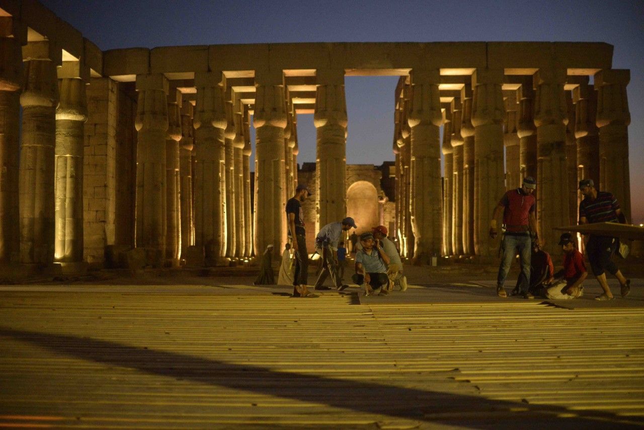 عمال مصريون داخل معبد الأقصر ضمن تجهيزات الفعالية - الشرق
