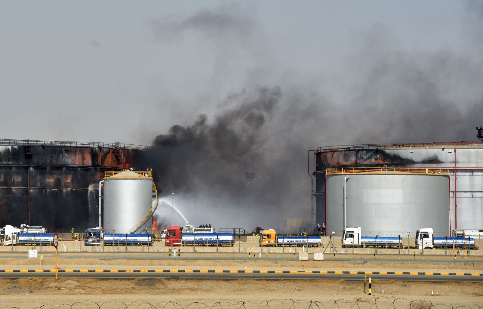 Fire fighters extinguish the last hearths of fire at a Saudi Aramco oil facility in Saudi Arabia's Red Sea coastal city of Jeddah, on March 26, 2022,  a day after a Yemeni rebels attack. - Yemeni rebels said they attacked a Saudi Aramco oil facility in Jeddah as part of a wave of drone and missile assaults today as a huge cloud of smoke was seen near the Formula One venue in the city. (Photo by AFP) - AFP