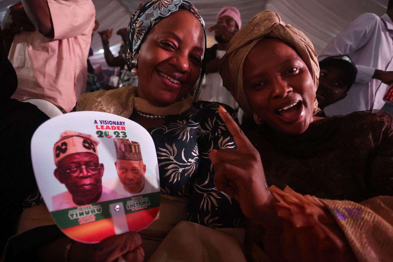 Supporters of the Nigerian presidential candidate Bola Tinubu, of the ruling All Progressive Congress (APC), celebrate in Abuja on March 1, 2023 at his campaign headquarters. - Ruling party candidate Bola Tinubu has won the most votes in Nigeria's highly disputed weekend election, according to final results on Wednesday, almost certainly securing him the presidency of Africa's most populous democracy. The Independent National Electoral Commission, or INEC, must still confirm whether Tinubu secured 25 percent of votes in two-thirds of Nigeria's 36 states and capital, a threshold he must hit to be confirmed president. (Photo by Kola SULAIMON / AFP) - AFP