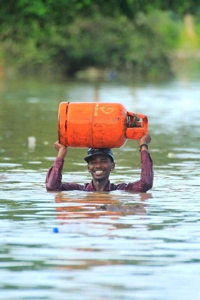 شاب سوداني يحمل أسطونة الغاز في وسط المياه  - فيسبوك
