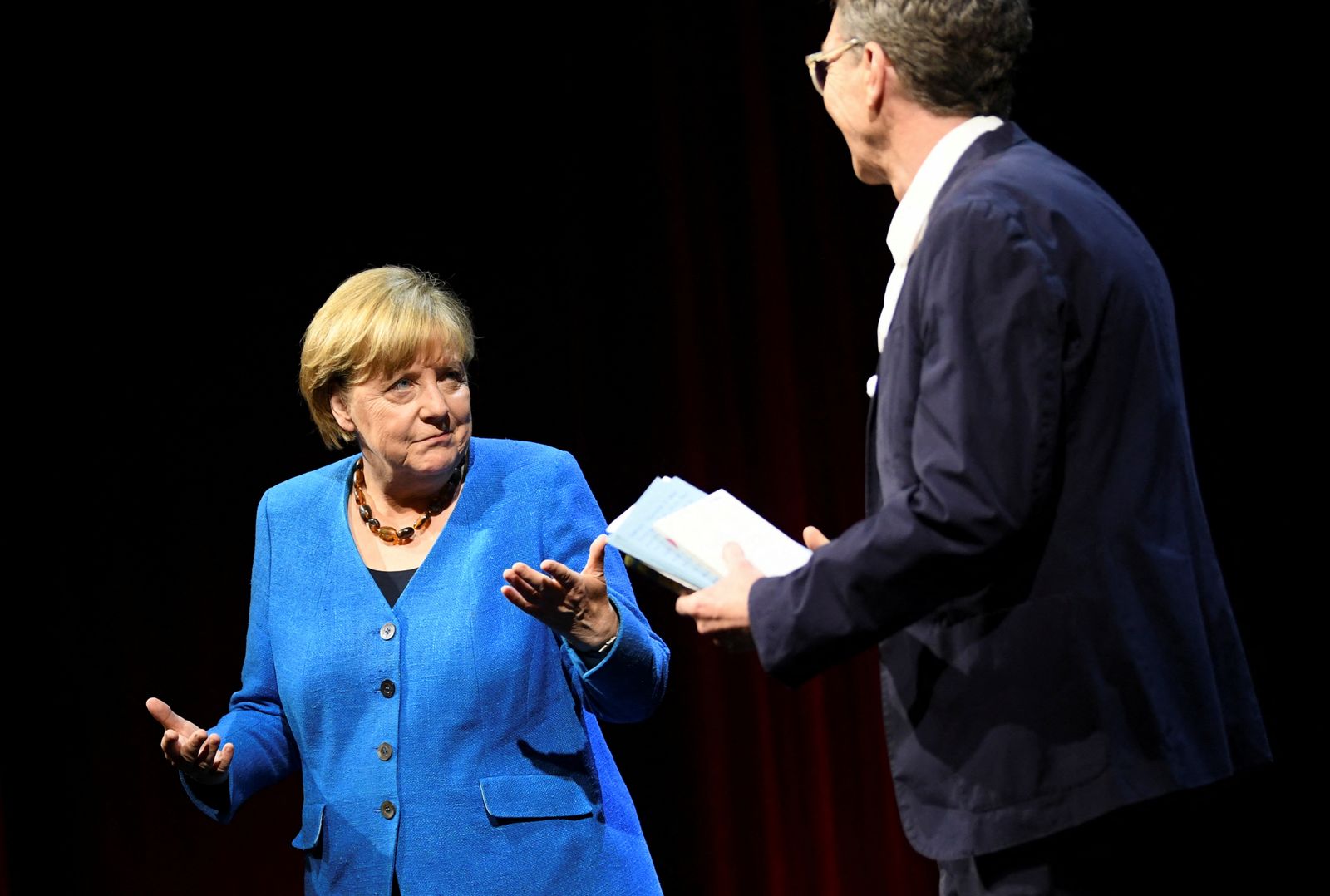 Former German Chancellor Angela Merkel talks with author Alexander Osang, in Berlin - REUTERS