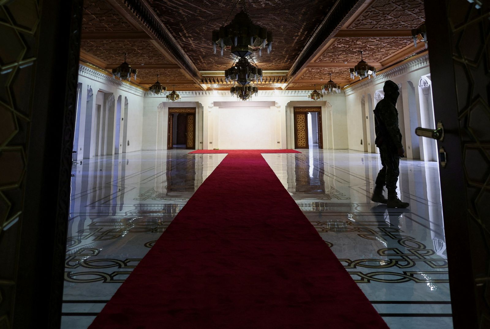 A rebel fighter walks inside the welcoming hall in the Presidential Palace known as Qasr al-Shaab 'People's Palace', after rebels seized the capital and ousted Syria's Bashar al-Assad, in Damascus, Syria December 10, 2024. REUTERS/Amr Abdallah Dalsh