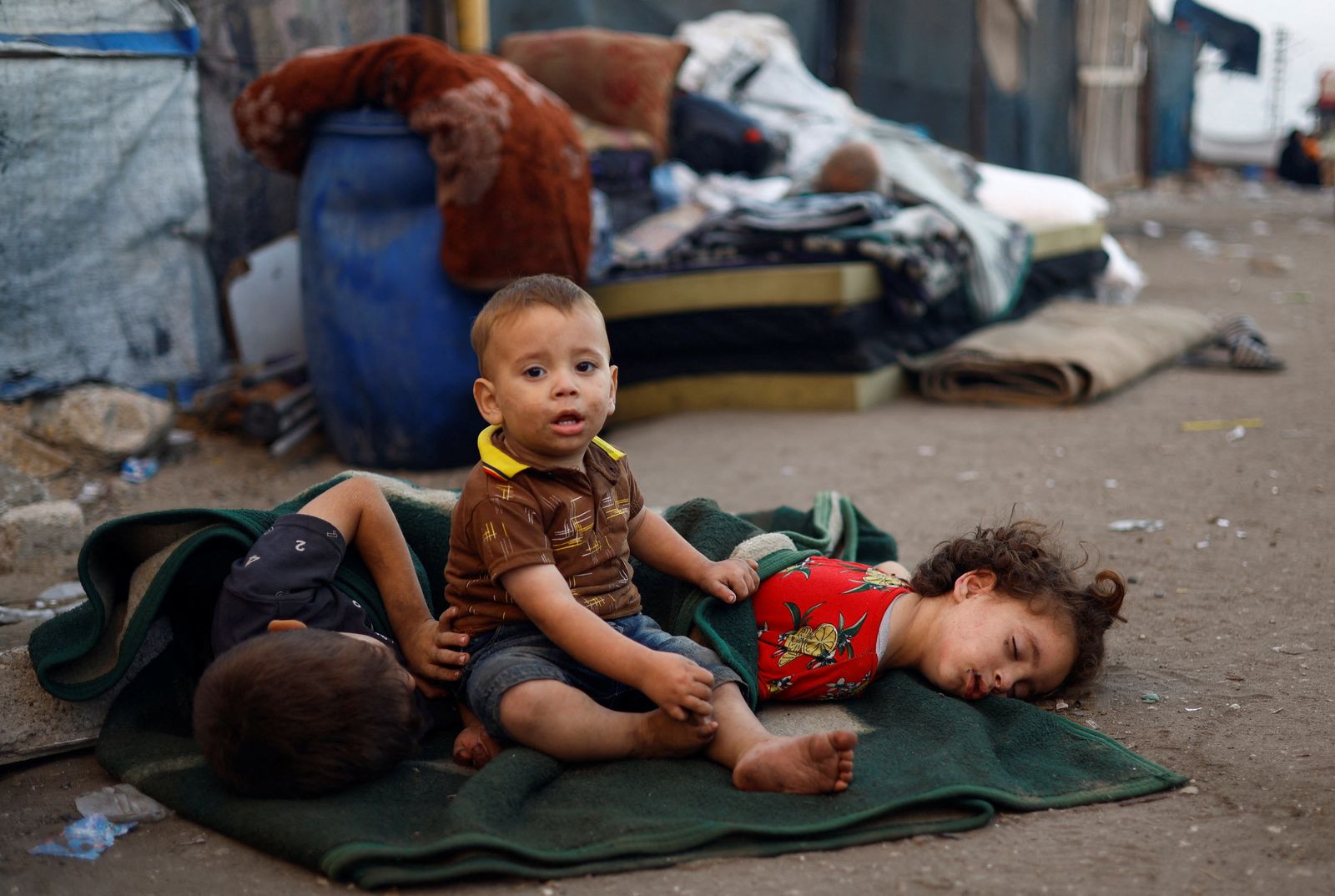 Children among displaced Palestinians fleeing northern Gaza due to an Israeli military operation rest on the way as they, along with others, move southward after Israeli forces ordered residents of Gaza City to evacuate to the south, in the central Gaza Strip, September 19, 2025. REUTERS/Mahmoud Issa