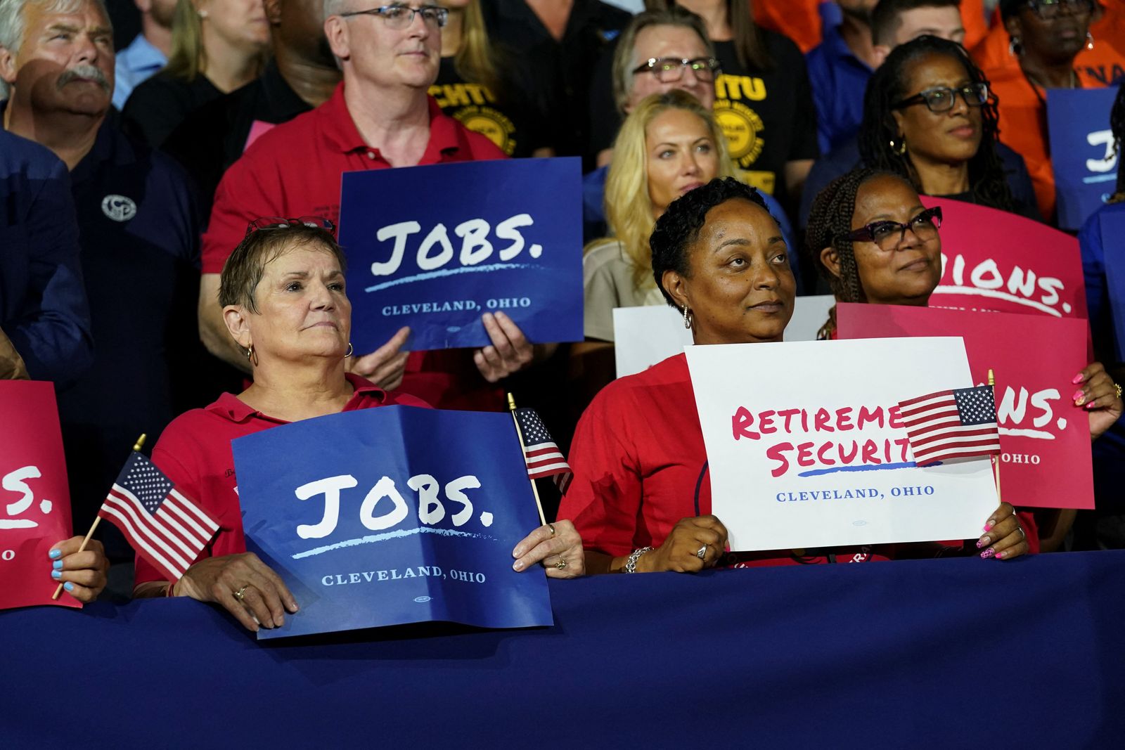 يحملون لافتات خلال كلمة يلقيها الرئيس الأميركي جو بايدن في كليفلاند - 6 يوليو 2022 - REUTERS