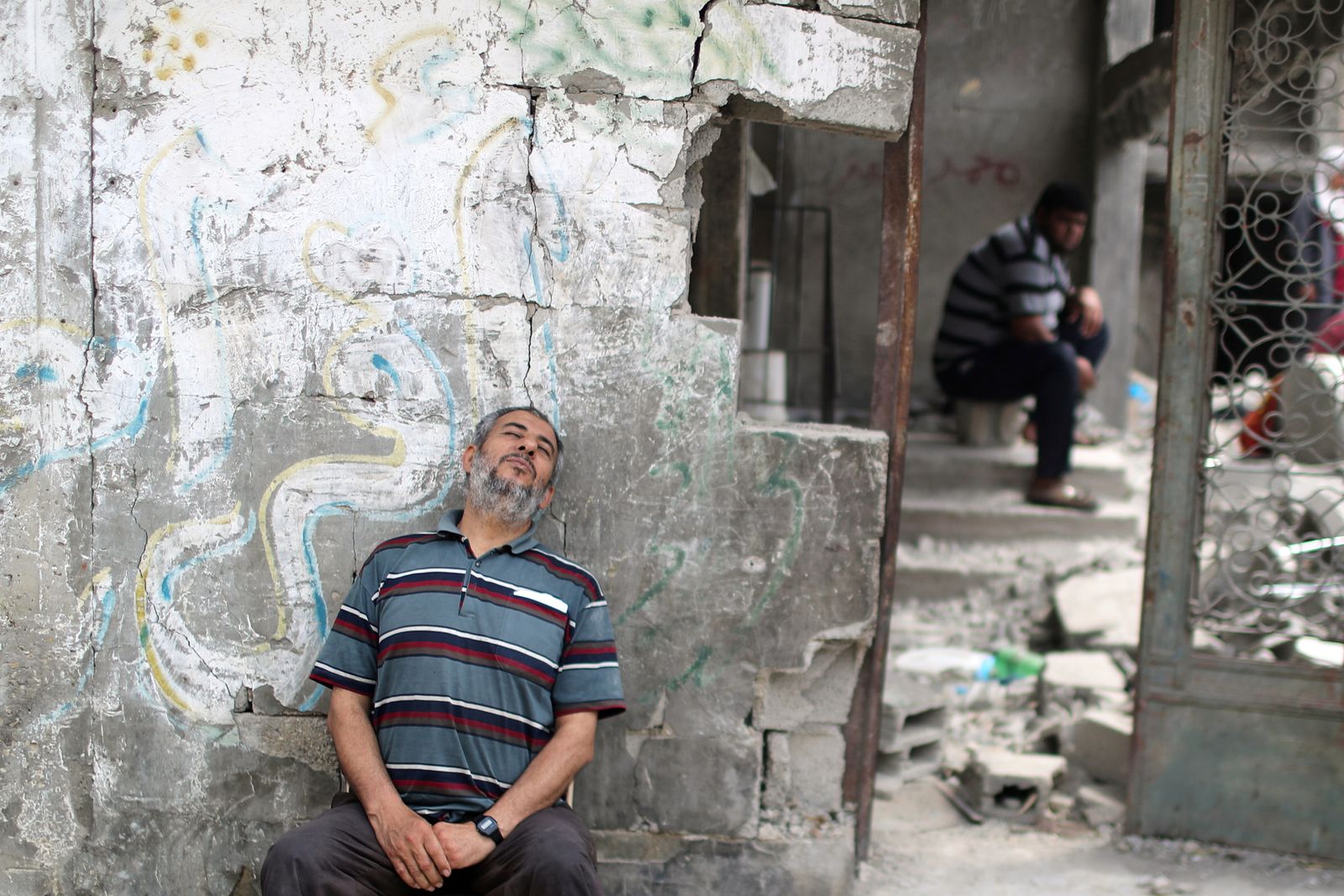 فلسطيني يستريح بعد عودته إلى منزله المدمر في بيت حانون شمال قطاع غزة - 21 مايو 2021 - REUTERS