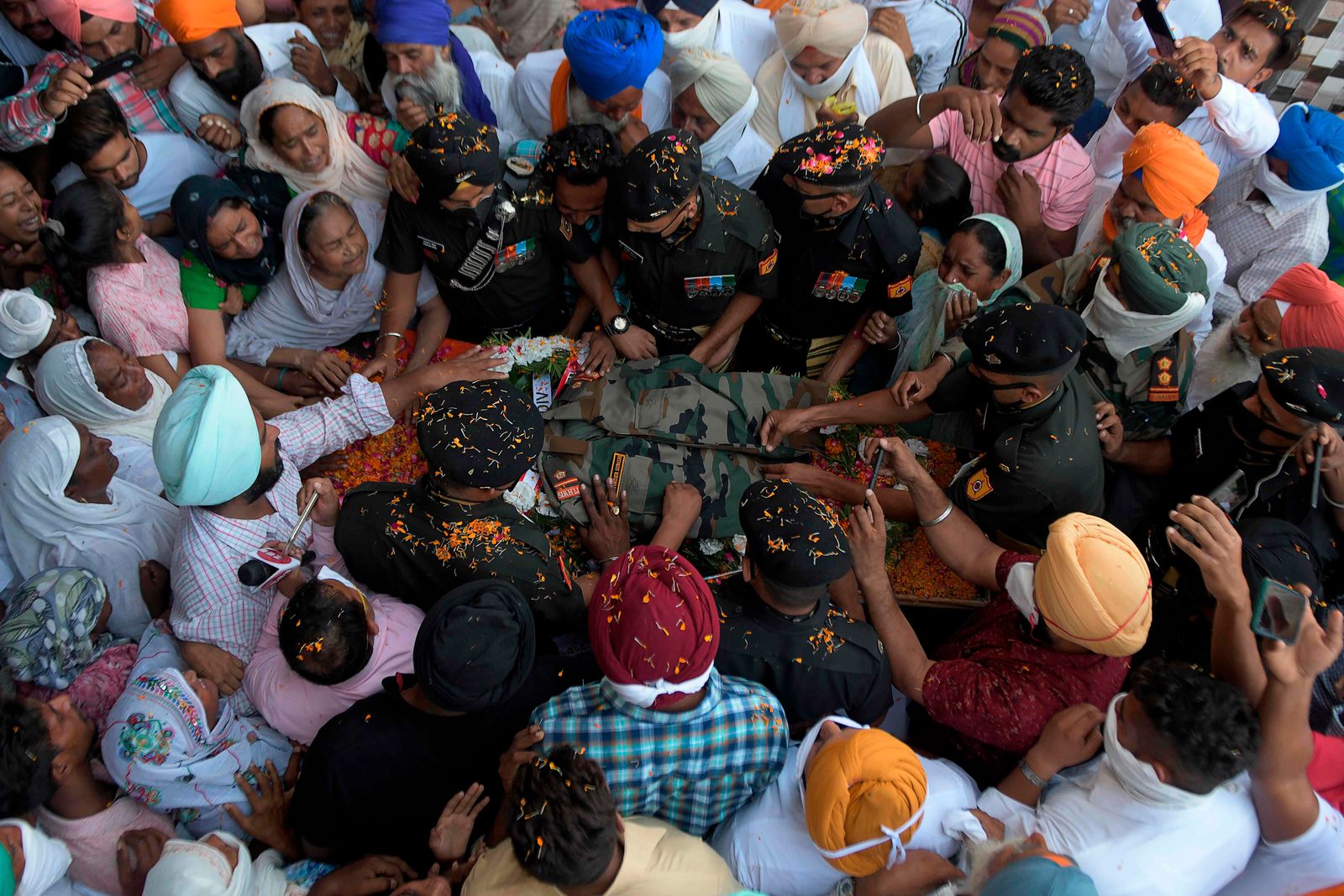 أفراد من الجيش الهندي يضعون الزي العسكري لزميلهم راجويندر سينغ ، الذي فقد حياته في انتهاك وقف إطلاق النار من قبل الجيش الباكستاني على خط السيطرة في قطاع ناوشيرا بجامو وكشمير ، خلال مراسم حرق الجثة في قرية جويندوال صاحب ، على بعد حوالي 50 كيلومترا من أمريتسار ، 31 أغسطس 2020 (تصوير ناريندر نانو / وكالة الصحافة الفرنسية) - AFP