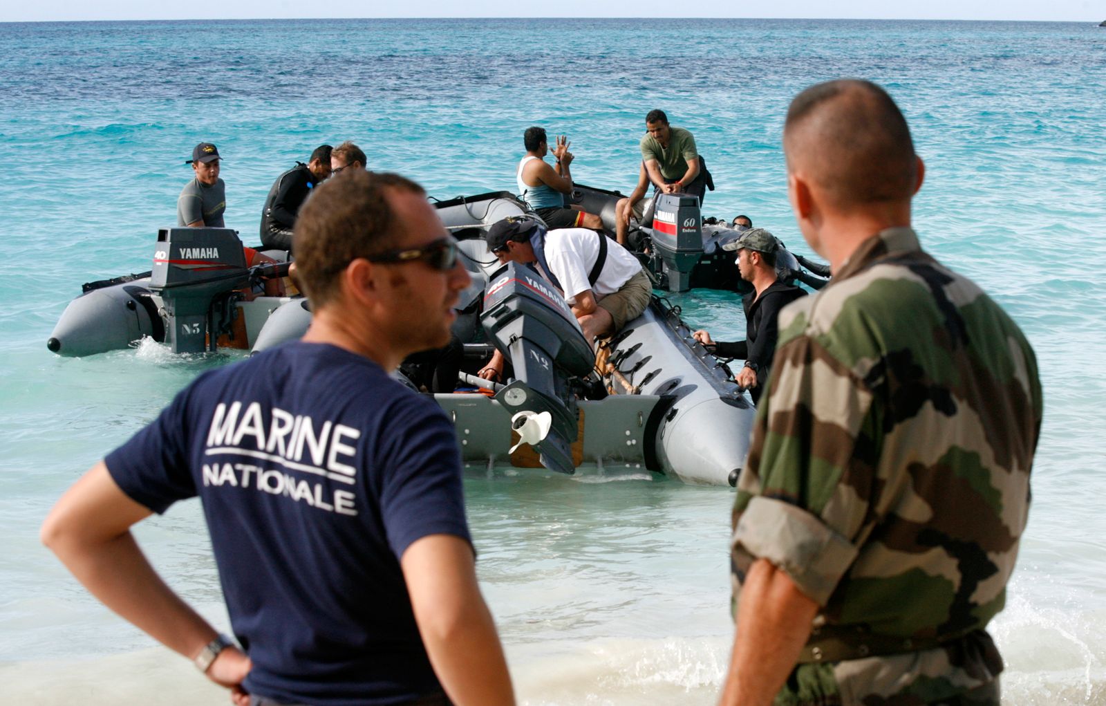 محققون فرنسيون يستعدون للمغادرة على متن زوارق سريعة في مهمة بحث عن الطائرة اليمنية المفقودة A310-300، في ميتساميولي، على بعد 30 كيلومتراً شمال مورونوي، عاصمة جزر القمر. 6 يوليو 2009. - REUTERS