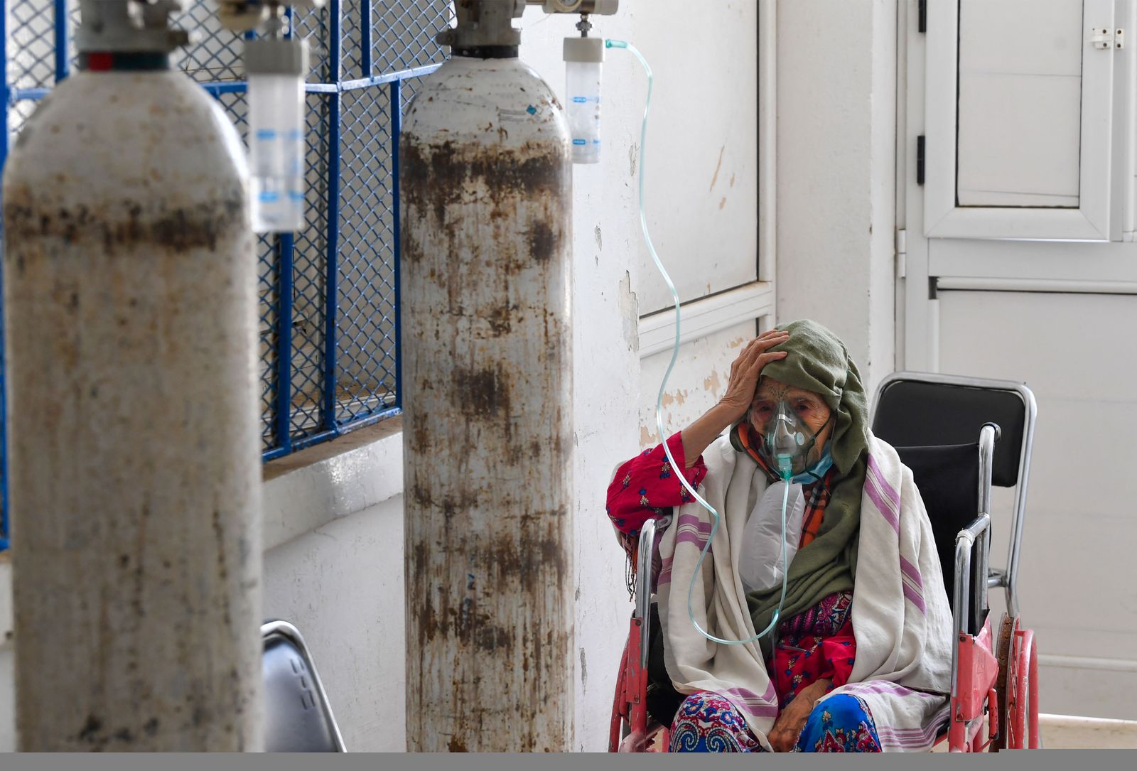 A Tunisian woman infected by the COVID-19 coronavirus receives oxygen at the Ibn al-Jazzar hospital in the east-central city of Kairouan on July 4, 2021. - Tunisia placed the capital Tunis and the northern town of Bizerte under a partial lockdown from until July 14 in a bid to rein in record daily coronavirus cases and deaths. (Photo by FETHI BELAID / AFP) - AFP