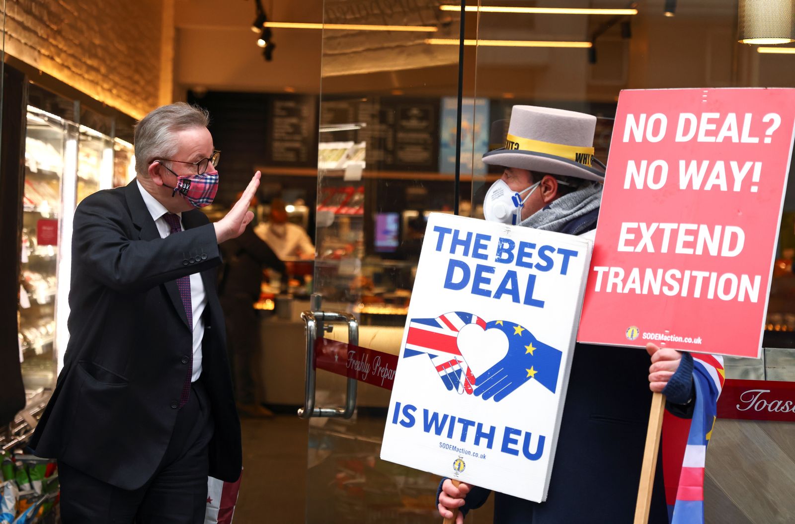 الوزير البريطاني مايكل غوف يحيّي مناهضاً لخروج المملكة المتحدة من الاتحاد الأوروبي، في مقهى بلندن - 30 نوفمبر 2020  - REUTERS