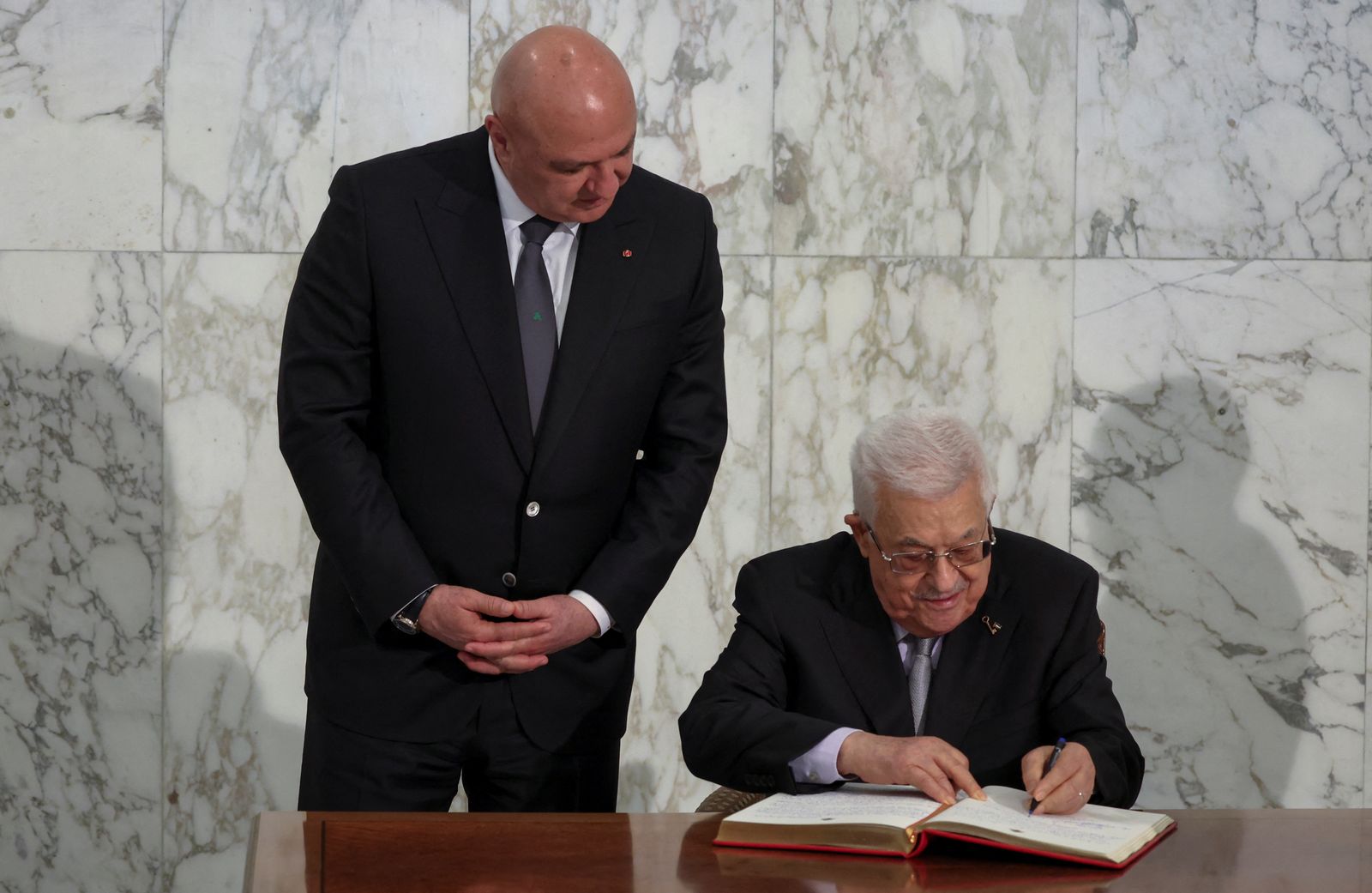 Palestinian President Mahmoud Abbas signs a guest book next to Lebanese President Joseph Aoun, at the presidential palace in Baabda, Lebanon May 21, 2025. REUTERS/Mohamed Azakir