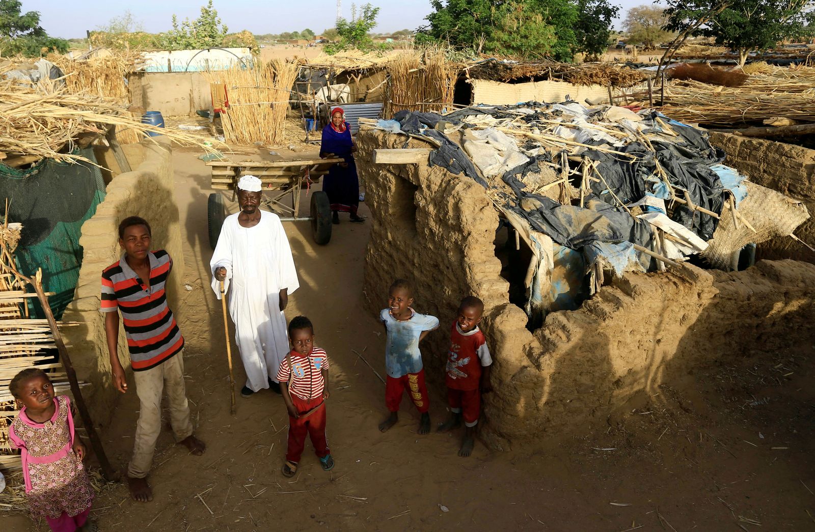 أسرة سودانية نازحة تقف خارج مأواها المؤقت داخل مخيم كلمة للنازحين داخلياً في دارفور - 26 أبريل 2019 - REUTERS