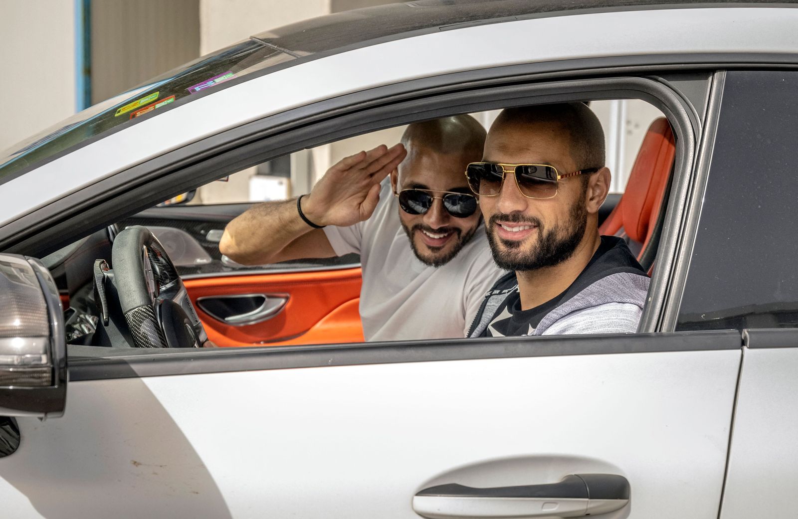 Moroccan footballer Noureddine Amrabat (C) waves as he leaves after disembarking from a ferry that arrived from Algeciras, in the Moroccan port of Tangiers, on June 15, 2022. - Thousands of Moroccan nationals working and living in Europe pass through the Strait of Gibraltar as they return to spend summer holidays in Morocco. (Photo by FADEL SENNA / AFP) - AFP