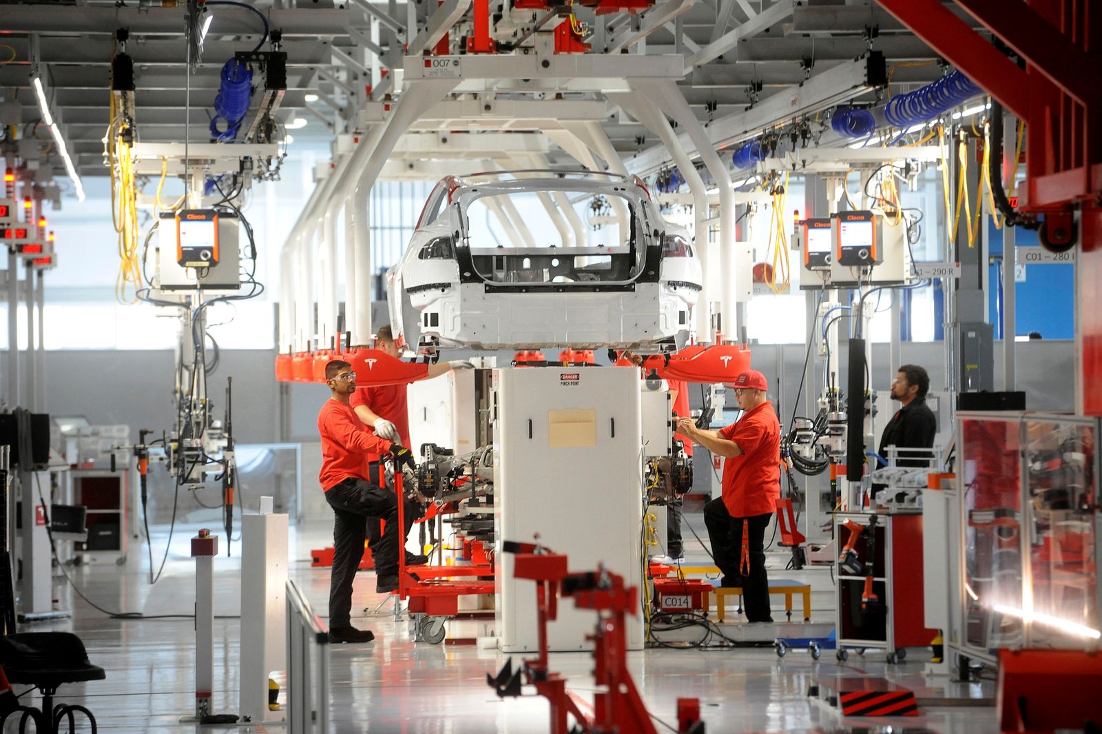 FILE PHOTO: Tesla workers examine a Model S used for training and tool calibration at the company's factory in Fremont - REUTERS