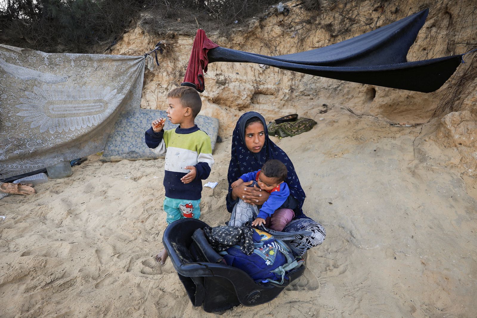 الفلسطينيون النازحون، الذين فروا من شمال غزة بعد أن أمرت القوات الإسرائيلية سكان مدينة غزة بالإخلاء إلى الجنوب وسط عملية عسكرية إسرائيلية، يستريحون بجوار ممتلكاتهم بينما يحتمون مؤقتًا على جانب الطريق، في وسط قطاع غزة، 30 سبتمبر 2025. رويترز/داود أبو الكاس