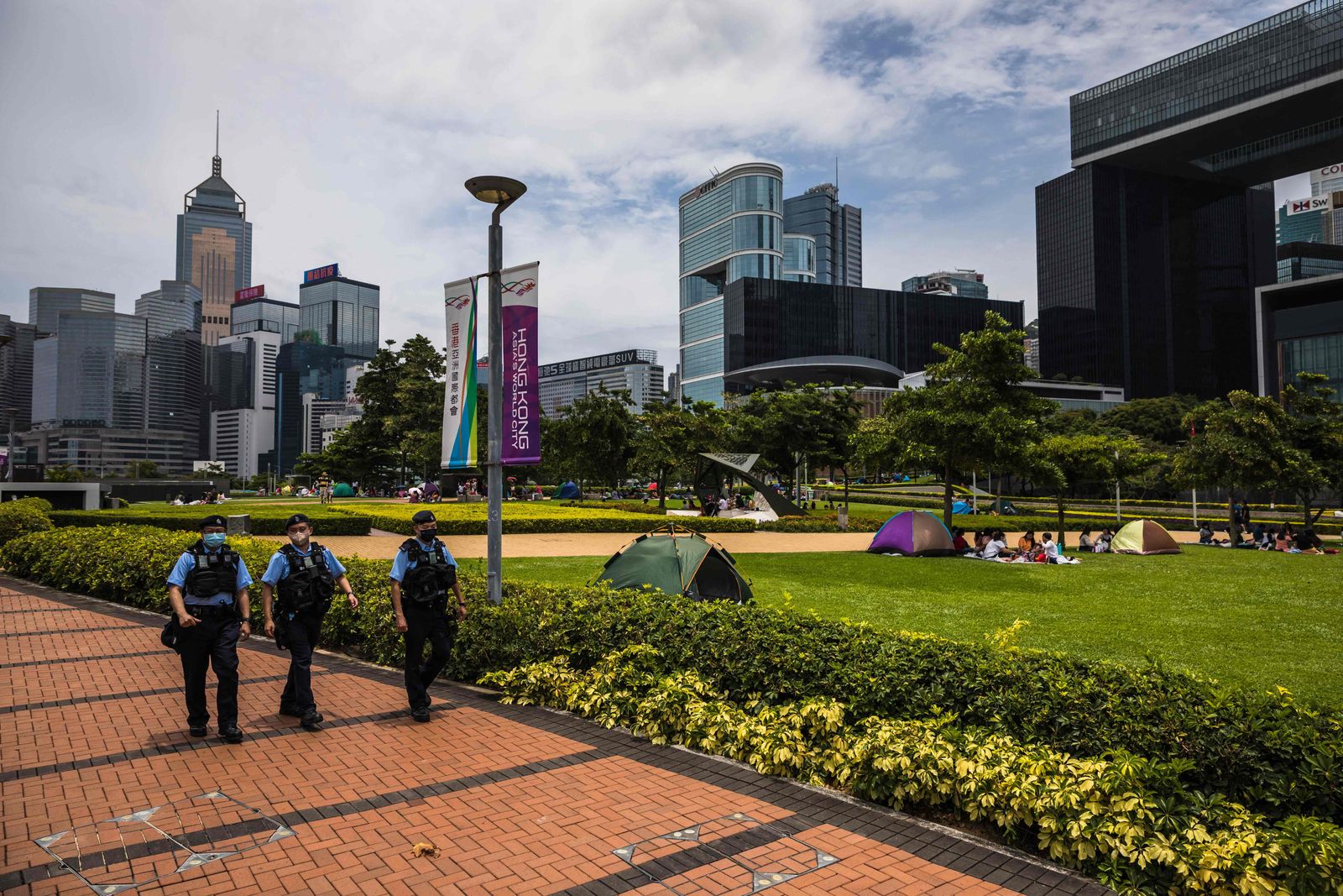 Police patrol near the government headquarters (R) in Hong Kong on May 8, 2022. - John Lee, a former security chief who oversaw the crackdown on Hong Kong's democracy movement, was anointed the business hub's new leader on May 8 by a small committee of Beijing loyalists. (Photo by DALE DE LA REY / AFP) - AFP