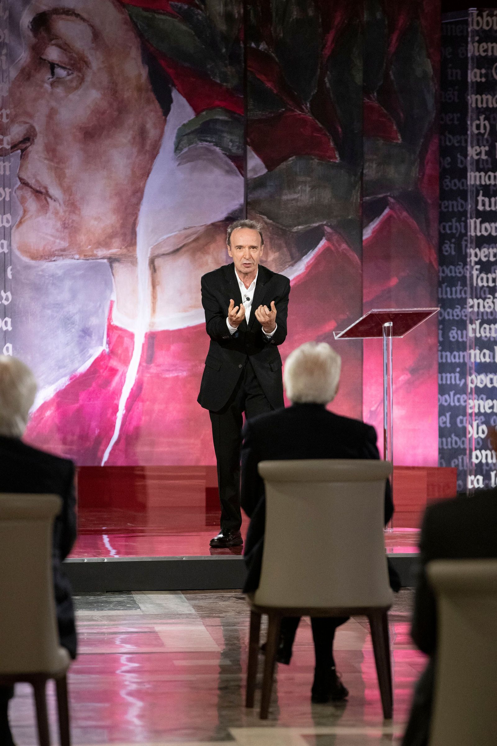 This photo taken and handout on March 25, 2021 by the Quirinale presidential press office shows Italian actor Roberto Benigni reciting Paradiso 25 (Canto XXV) from Dante's Divine Comedy, with Italian President Sergio Mattarella (Front from behind) attending, at the Quirinale palace in Rome in celebrations of the 700th anniversary of the death of Italian poet, writer and philosopher Dante Alighieri. (Photo by Handout / Quirinale Press Office / AFP) / RESTRICTED TO EDITORIAL USE - MANDATORY CREDIT 