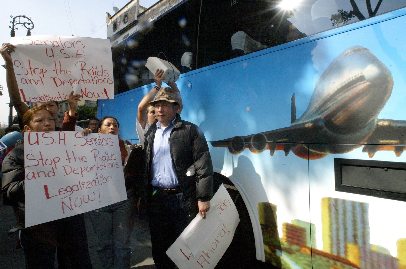 نشطاء هجرة يتظاهرون خلال وصول مجموعة من أعضاء الكونجرس الأميركي بقيادة زعيم الأغلبية الديمقراطية السابق في مجلس الشيوخ هاري ريد، إلى مجلس الشيوخ المكسيكي في مكسيكو سيتي، 29 نوفمبر 2007 - AFP