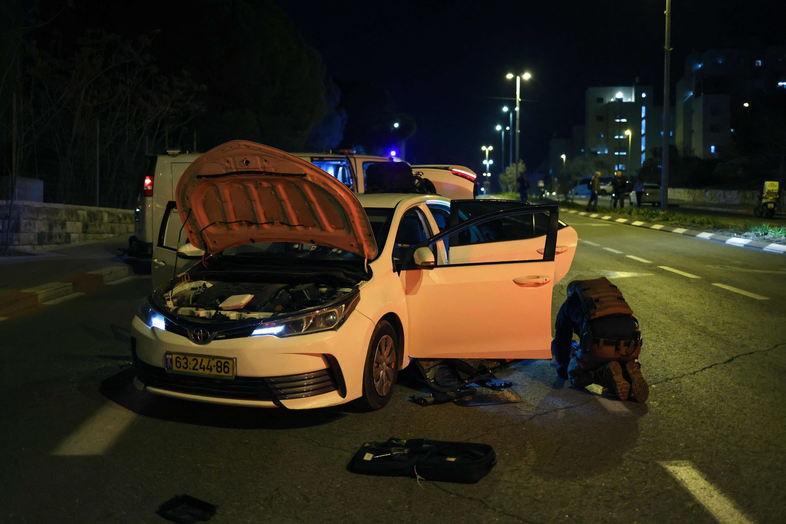 EDITORS NOTE: Graphic content / Israeli security forces search a car at the site of a reported attack in a settler neighbourhood of Israeli-annexed east Jerusalem, on January 27, 2023. (Photo by RONALDO SCHEMIDT / AFP) - AFP