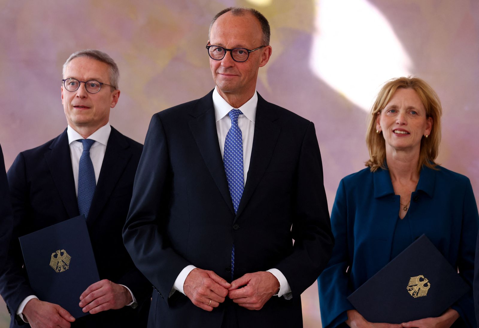 German Chancellor Friedrich Merz looks on as designated German Family Minister Karin Prien and designated German Minister for Digitalization and State Modernization Karsten Wildberger hold their certificates of appointment during a ceremony at Bellevue Palace in Berlin, Germany May 6, 2025. REUTERS/Annegret Hilse