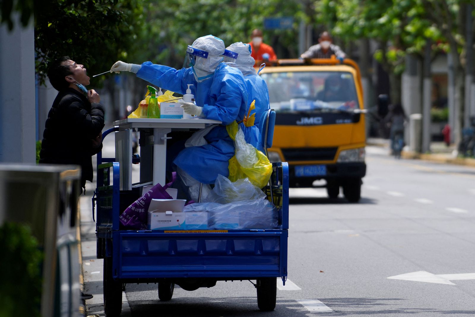 رجل يخضع لفحص كورونا خلال مختبر متنقل لجمع العينات في أحد شوارع شنغهاي. 30 أبريل 2022 - REUTERS
