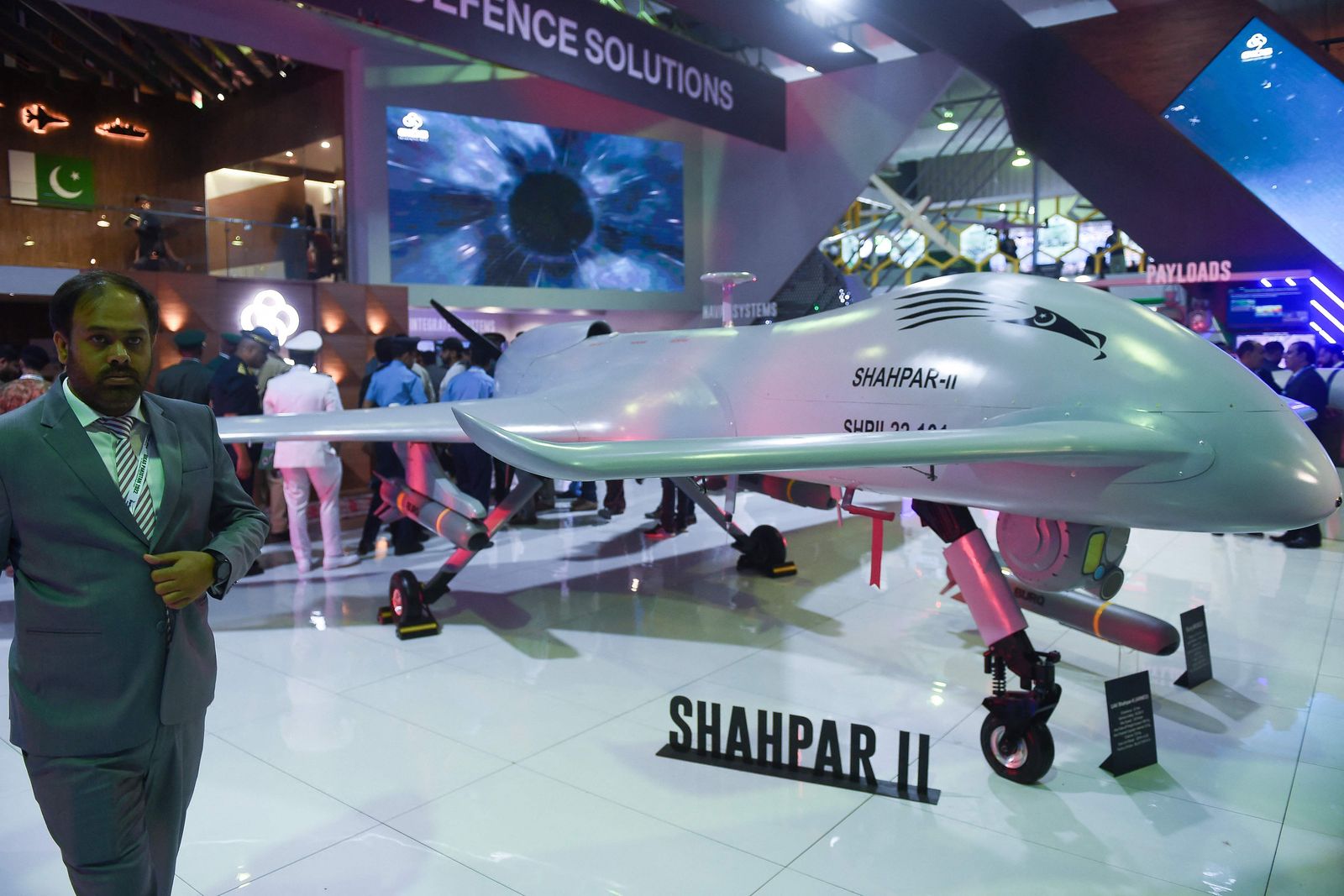 Military officials walk past a Pakistan�s unmanned combat aerial vehicle Shahpar-II during International Defence Exhibition and Seminar (IDEAS) 2022 at the Expo Centre in Karachi on November 16, 2022. (Photo by Rizwan TABASSUM / AFP)