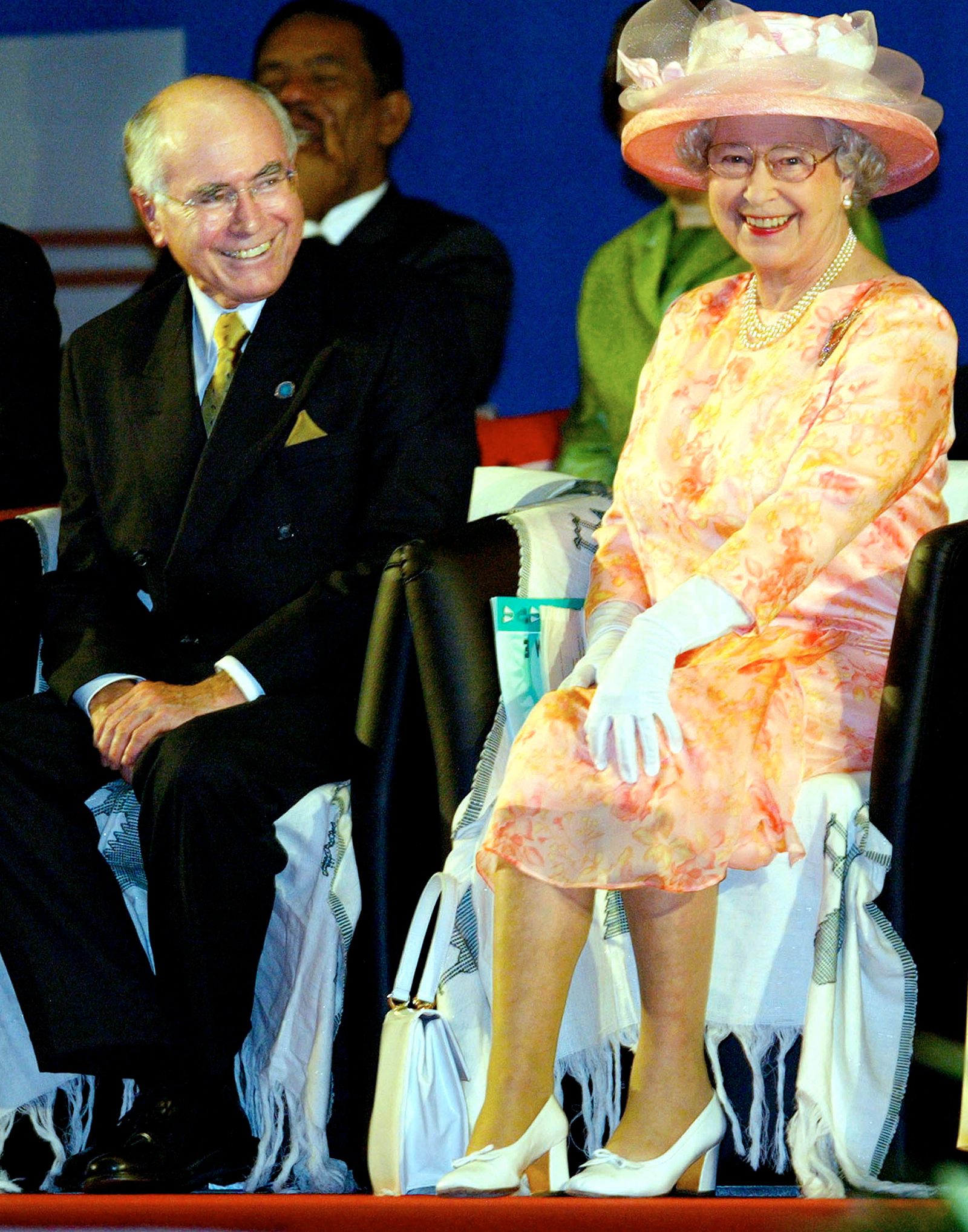 الملكة إليزابيث الثانية (إلى اليمين) مع رئيس الوزراء الأسترالي جون هوارد في الجلسة الافتتاحية لقمة الكومنولث في أبوجا في 5 ديسمبر 2003. - REUTERS