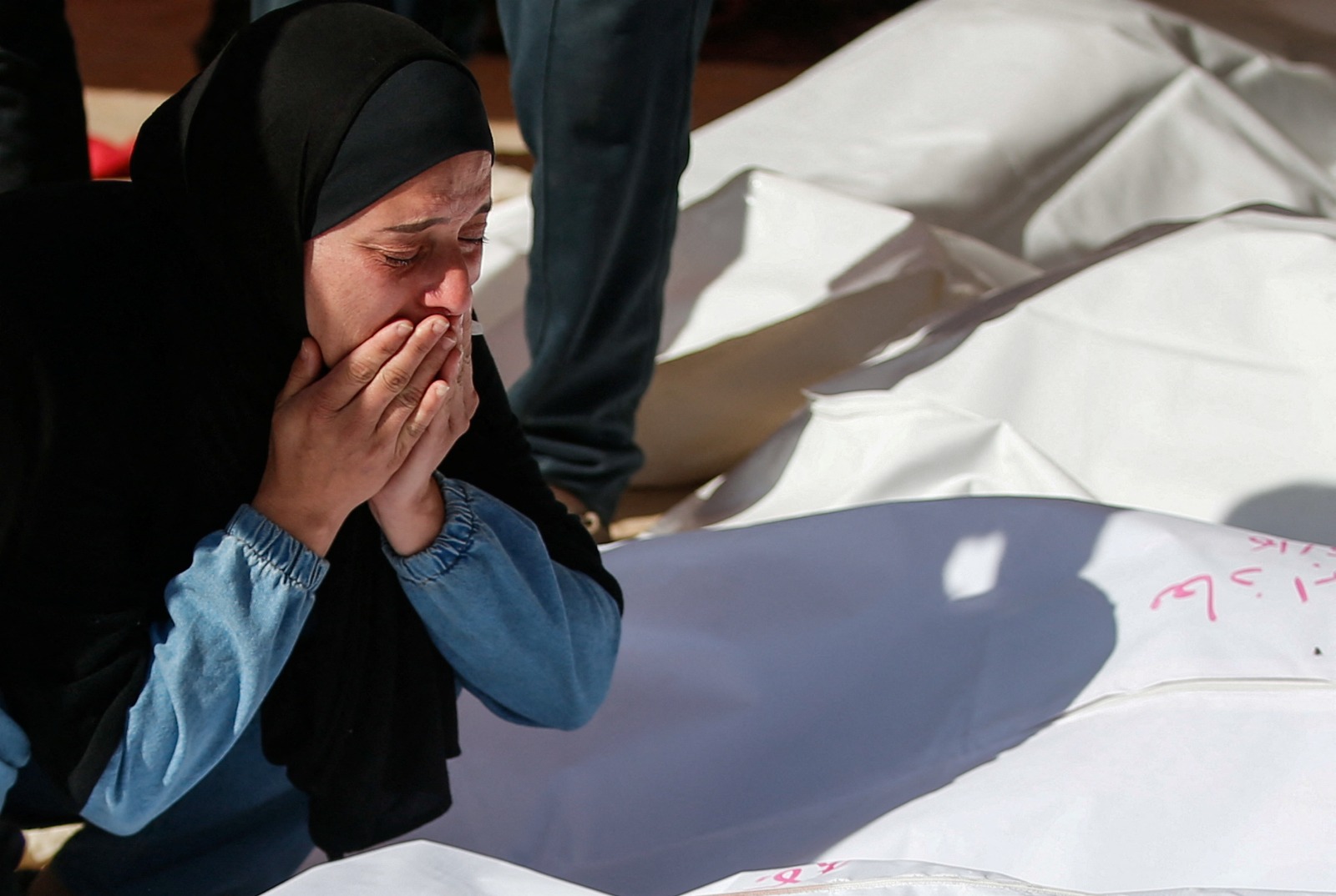 امرأة فلسطينية تجلس أمام جثامين قتلتهم غارات إسرائيلية، في بيت لاهيا بشمال قطاع غزة. 16 مايو 2025
