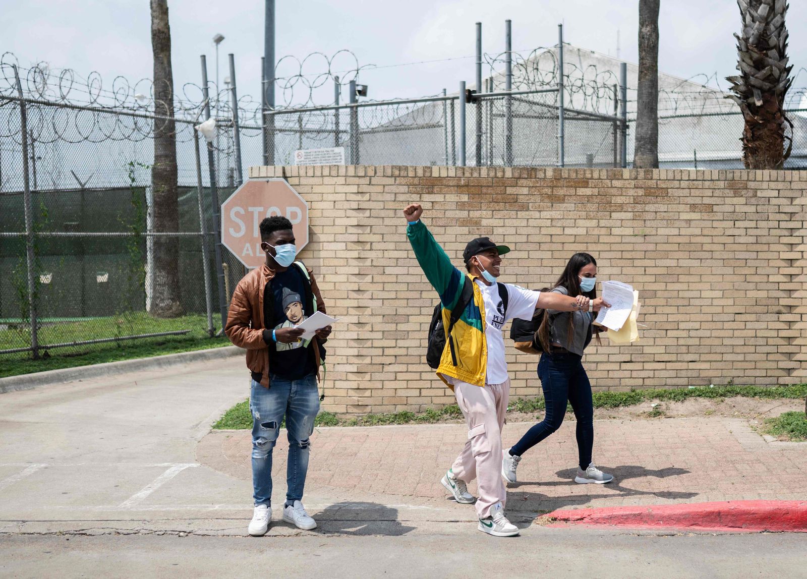 TOPSHOT - Neiker Medina (C) and Milenny Ruiz (R) from Venezuela celebrate their arrival into the United States after obtaining an appointment to legally enter the country from Mexico on May 12, 2023 in Brownsville, Texas. The US on May 11, 2023, will officially end its 40-month Covid-19 emergency, also discarding the Title 42 law, a tool that has been used to prevent millions of migrants from entering the country. (Photo by ANDREW CABALLERO-REYNOLDS / AFP) - AFP