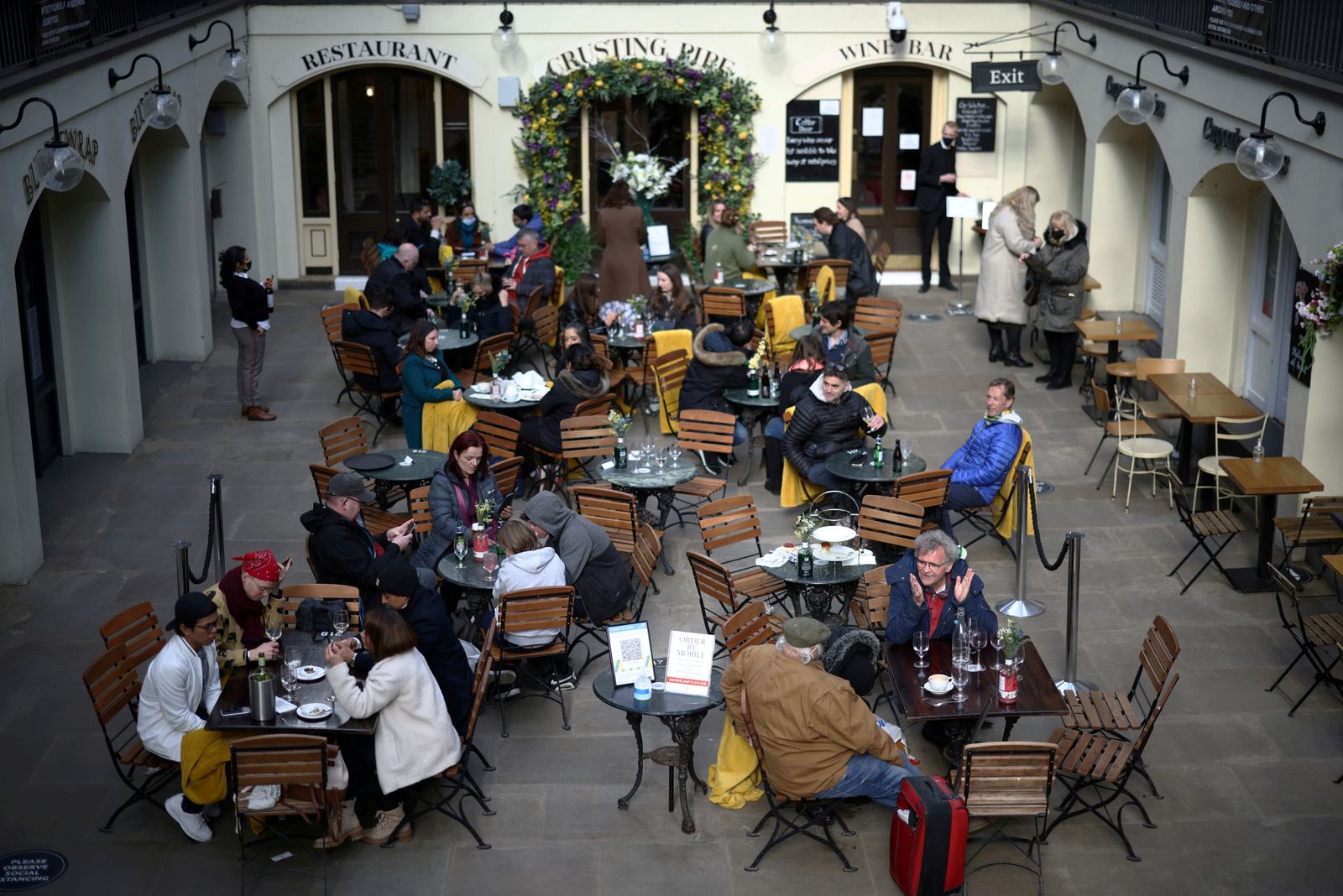أضحى بإمكان البريطانيين الاستمتاع بالجلوس في باحات المطاعم بع مع تخفيف قيود فيروس كورونا، لندن، 12 أبريل 2021 - REUTERS