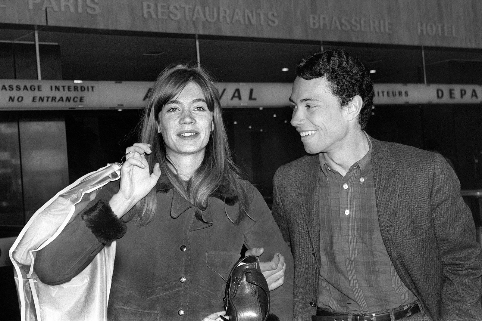 (FILES) French singer Francoise Hardy walks through the arrival gates at Paris Orly airport with her partner, photographer Jean-Marie Perier on April 13, 1965 after landing from New York. French singer Francoise Hardy, has died at the age of 80, her son Thomas Dutronc announced on June 11, 2024 on his social networks. Singer, actress and songwriter, mainly known for her melancholic sentimental ballads, Fran�oise Hardy made her musical debut in the early 1960s and found immediate success with the song 'Tous les gar�ons et les filles'. In addition to her native French, she also sang in English, Italian and German. Her career spanned more than fifty years and almost 30 studio albums. One of the best-selling singers in French history, she is regarded as an iconic and influential figure in both French pop and fashion. (Photo by AFP)