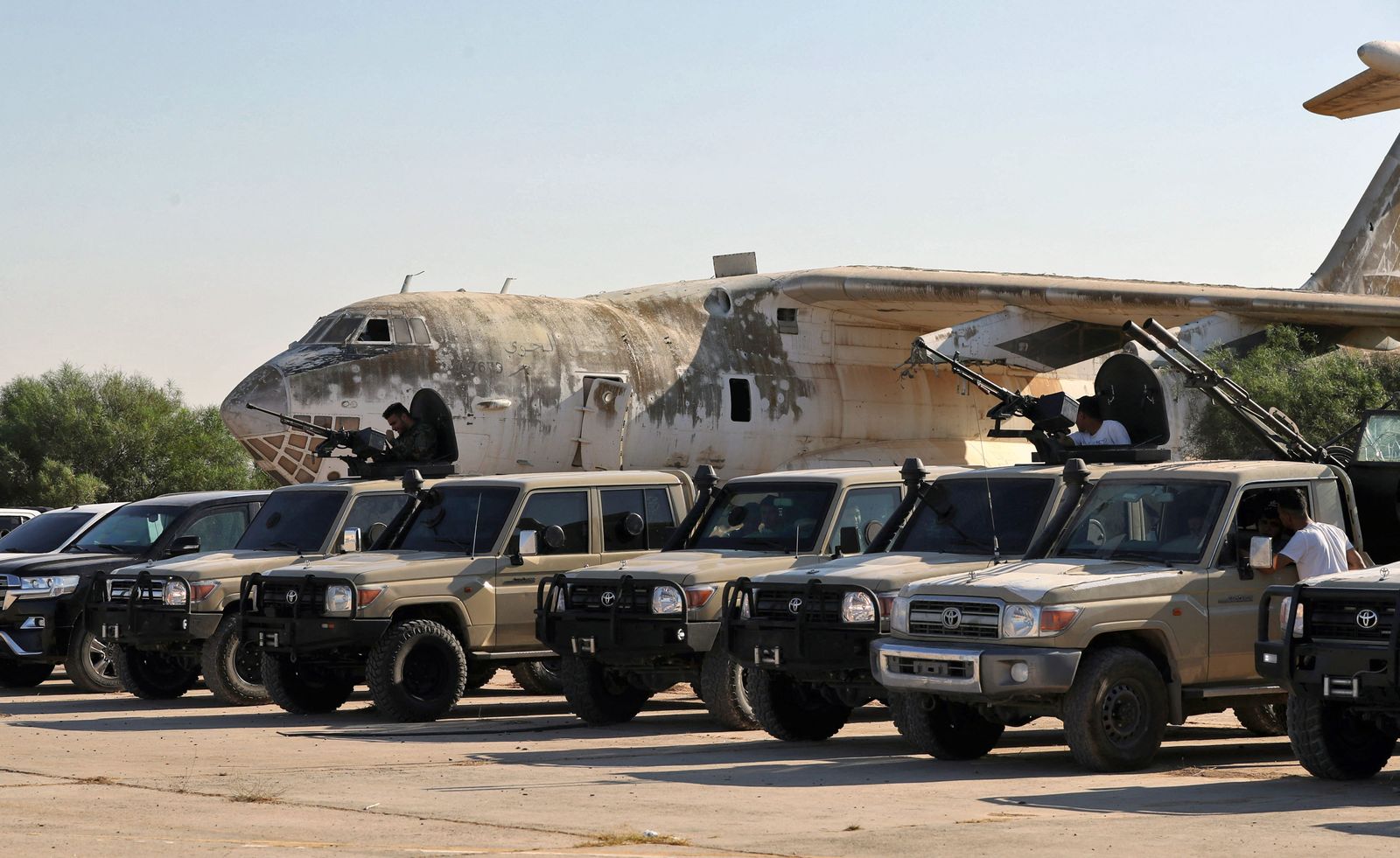 Joint forces affiliated with Libya's Government of National Unity assemble inside the closed Tripoli International Airport, as they deploy on the outskirts and entrances of the capital Tripoli on July 25, 2022. - At least 16 people were killed and 52 wounded in fighting between armed groups in Tripoli, the health ministry said on July 23, following the latest politically driven violence to hit the Libyan capital. (Photo by Mahmud Turkia / AFP) - AFP