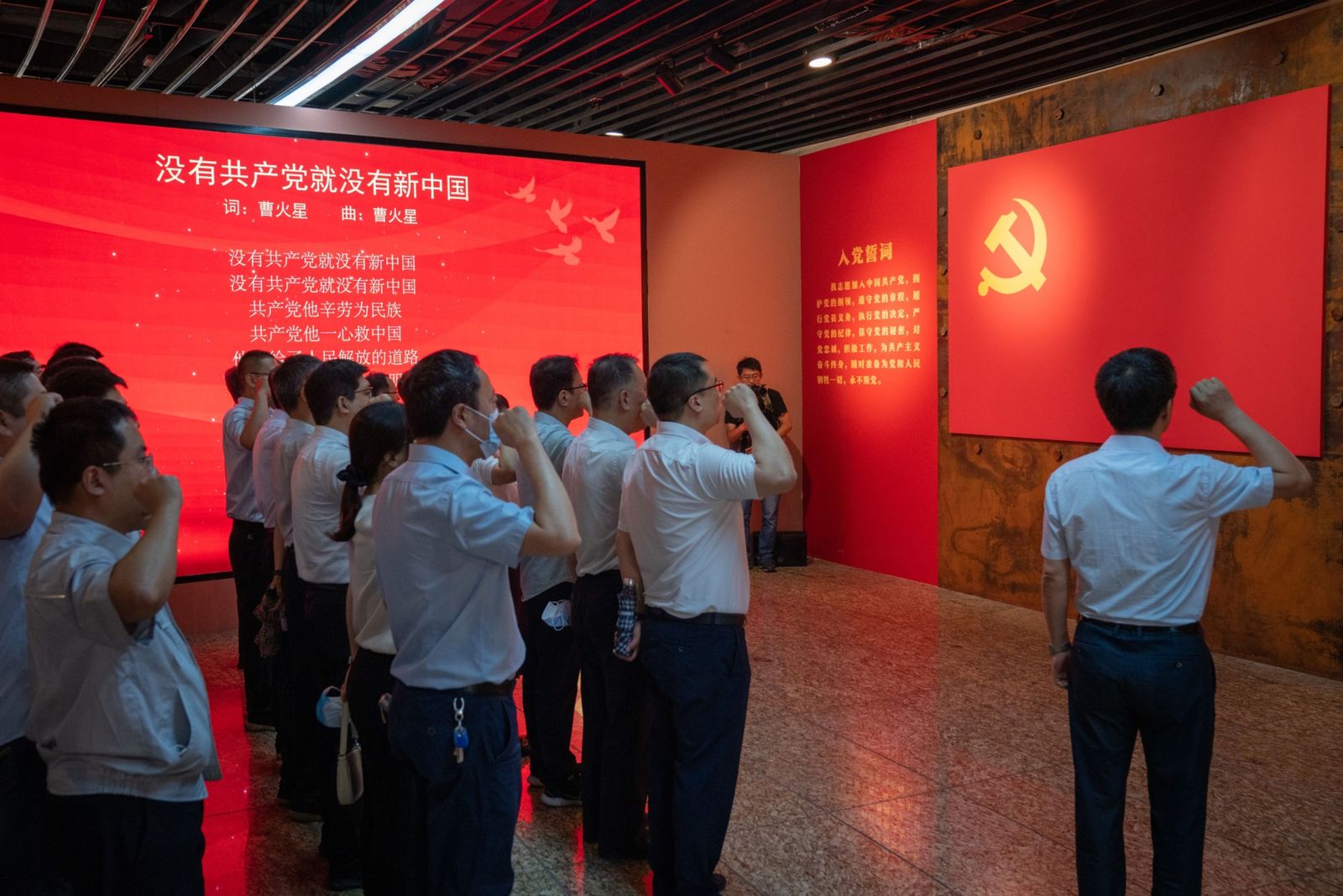 يتلون قسم الحزب الشيوعي الصيني أمام علمه في معرض ببكين - 25 يونيو 2021 - Bloomberg
