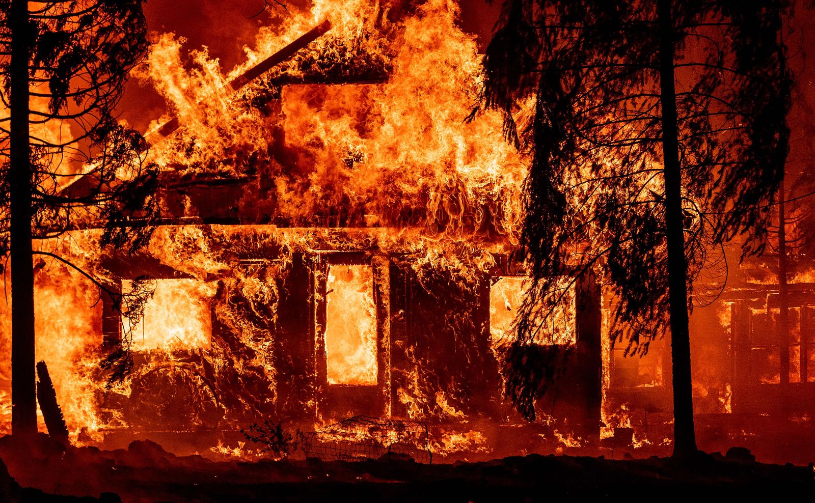 A home burns as flames from the Dixie fire tear through the Indian Falls neighborhood of unincorporated Plumas County, California on July 24, 2021. - The Dixie fire, which started only a few miles from the origin of the deadly Camp fire, has churned through more than 185,000 acres and continues to burn towards rural communities. (Photo by JOSH EDELSON / AFP) - AFP
