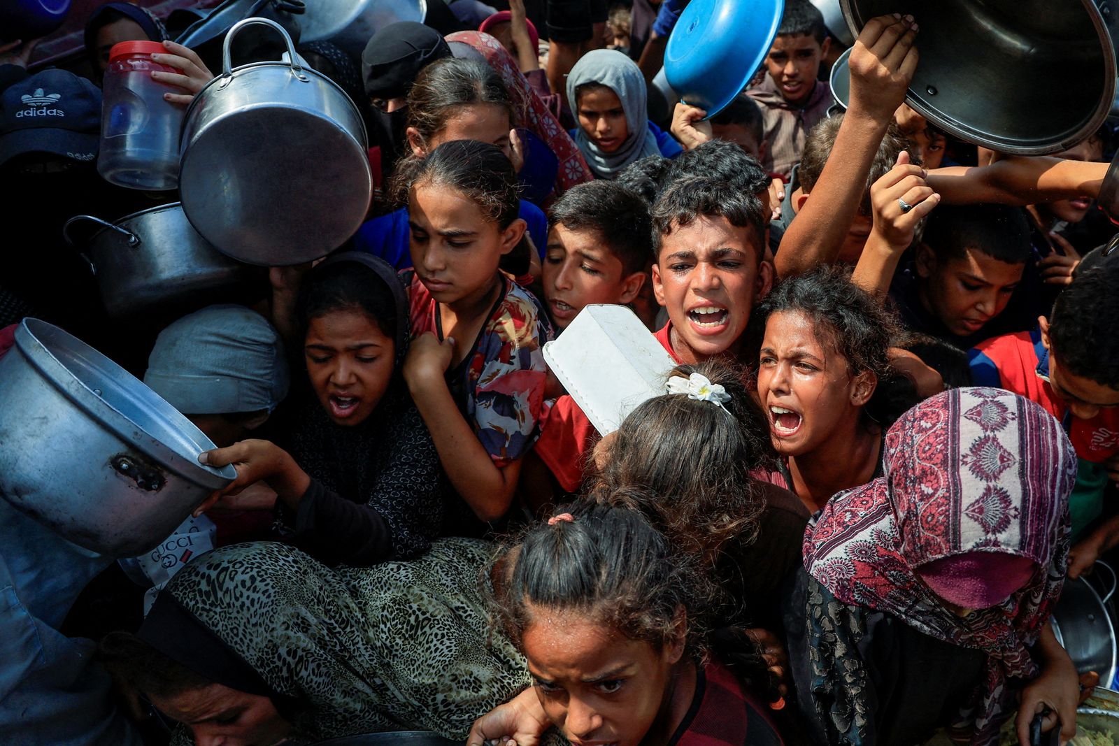 FILE PHOTO: Palestinians wait to receive food from a charity kitchen, in Khan Younis, southern Gaza Strip, August 21, 2025. REUTERS/Hatem Khaled/File Photo