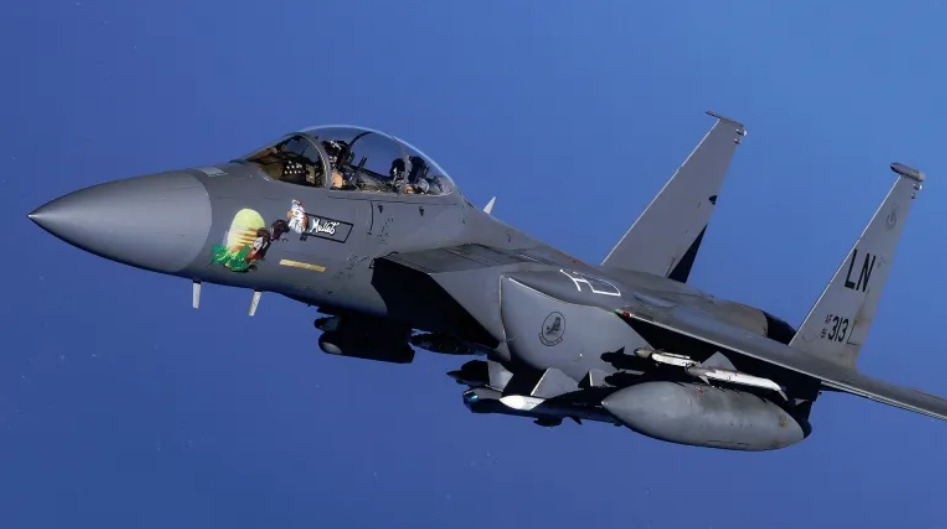 صورة أرشيفية لطائرة F-15E تحمل صاروخين من طراز AIM-9X Sidewinders تحت جناحها الأيسر، وصاروخ AIM-120 مُحمّل على أحد أبراج منصة الإطلاق على الجانب الأيسر من جسم الطائرة. كما تظهر قنابل دقيقة التوجيه متنوعة في محطات أخرى.
