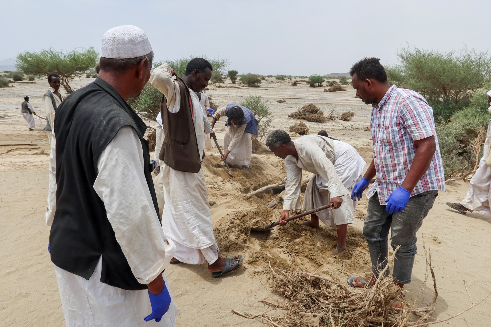 أشخاص يحفرون قبراً لدفن قريب لقي حتفه جراء فيضانات مدمرة في بورتسودان. 26 أغسطس 2024