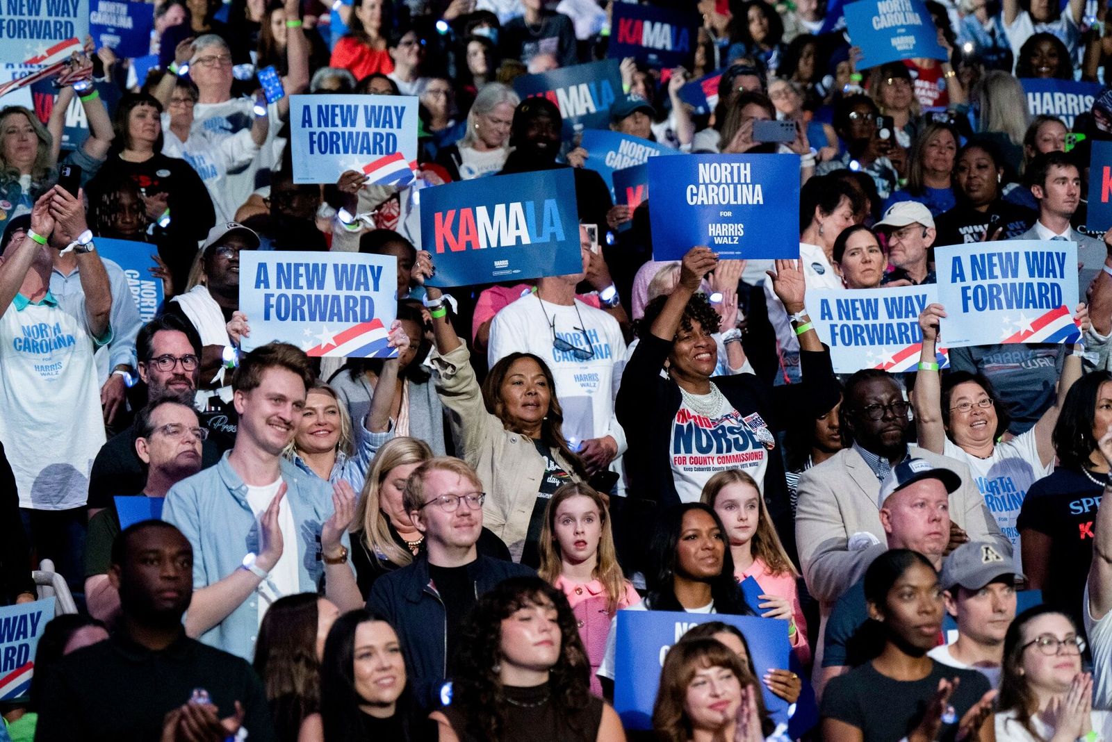 Attendees hold signs during a campaign event with US Vice President Kamala Harris, not pictured, at Bojangles Arena in Charlotte, North Carolina, US, on Thursday, Sept. 12, 2024. Harris is looking to harness the momentum from her strong showing in Tuesday's presidential debate with a tour of key swing states, even as her Republican opponent, Donald Trump, is about to embark on a trip to the West, where he'll be pressed to show donors and supporters a plan to regain his footing. Photographer: Allison Joyce/Bloomberg