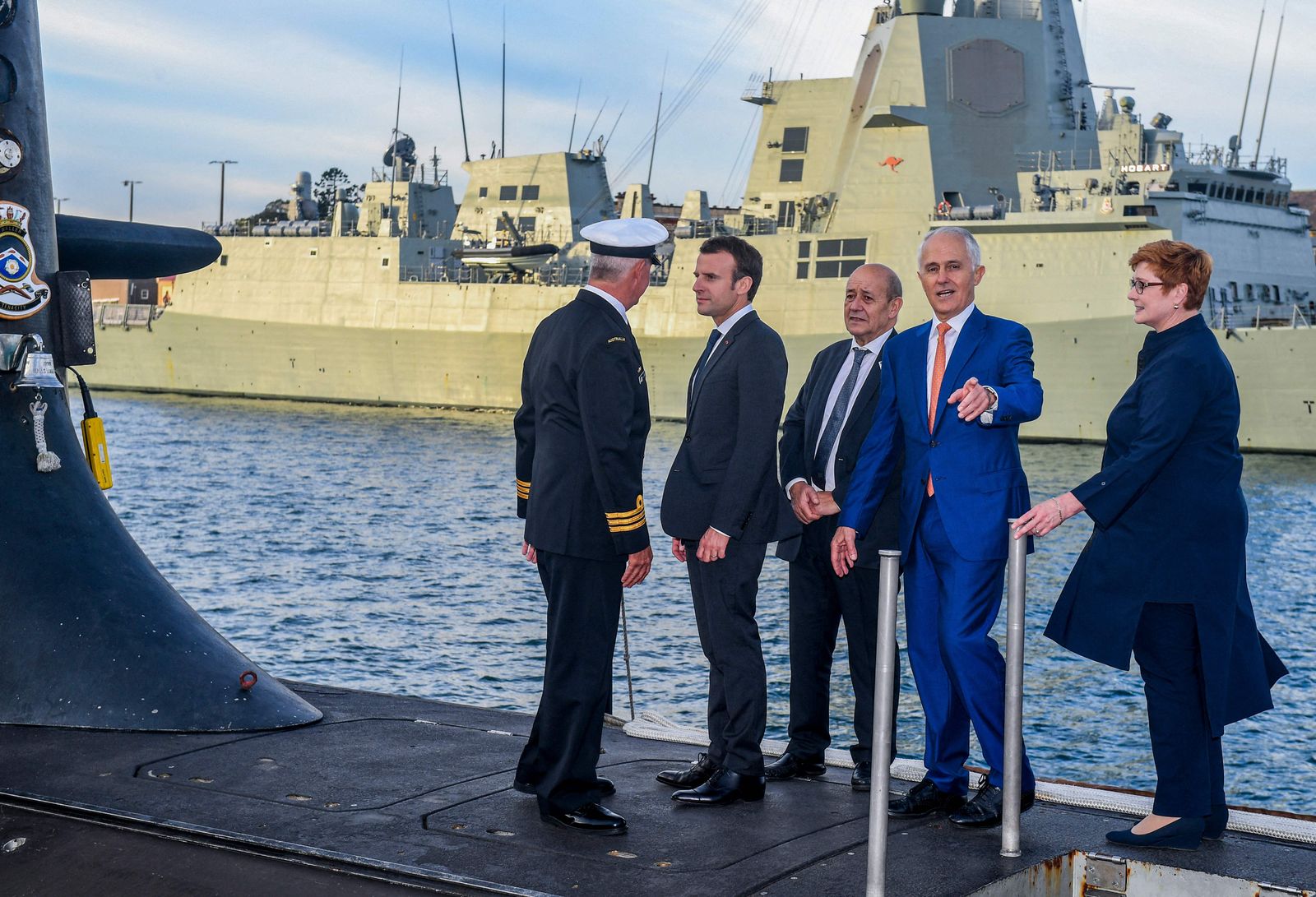 (FILES) A file photo taken on May 2, 2018 shows French President Emmanuel Macron (2/L) and Australian Prime Minister Malcolm Turnbull (2/R) standing on the deck of HMAS Waller, a Collins-class submarine operated by the Royal Australian Navy, at Garden Island in Sydney. - Australia is expected to scrapped a 66 billion USD deal for France to build submarines, replacing it with nuclear-powered subs using US and British technology. (Photo by BRENDAN ESPOSITO / POOL / AFP) - AFP