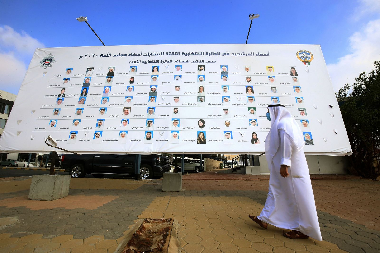 A Kuwaiti man walks by a billboard featuring the candidates running for parliamentary elections in Kuwait City, on November 30, 2020. - Kuwait's National Assembly elections are scheduled for December 5, 2020. (Photo by YASSER AL-ZAYYAT / AFP) - AFP