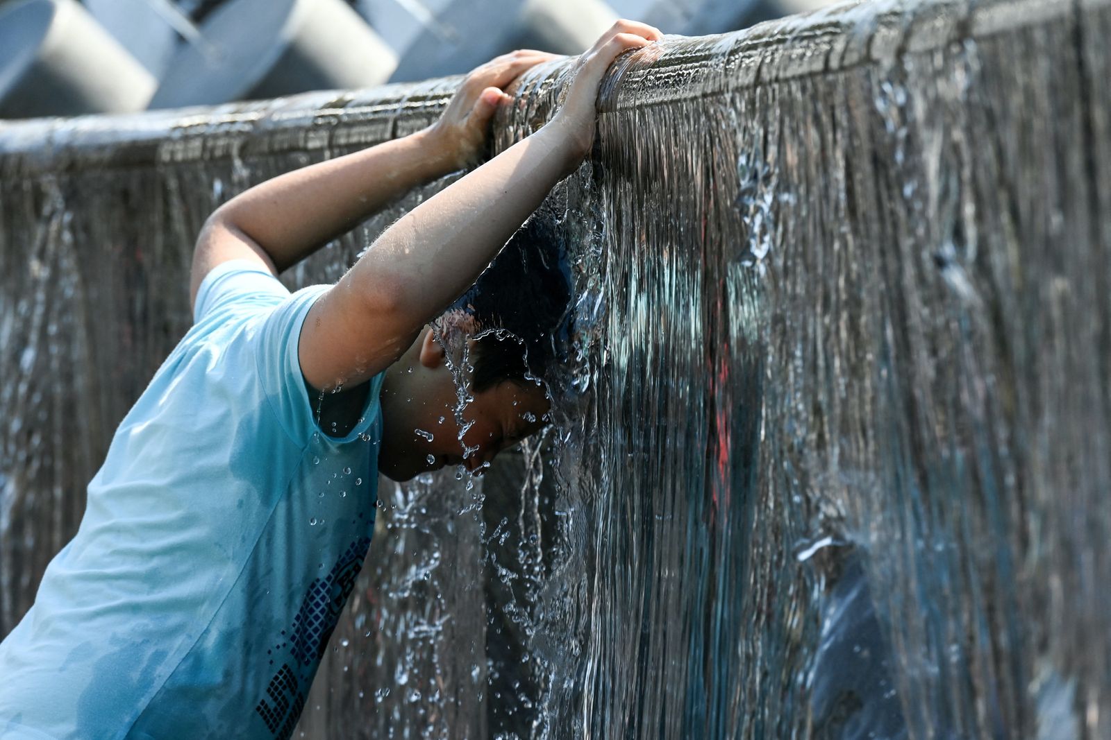 شاب يضع رأسه تحت الماء في محاولة لتبريد حرارة جسمه بسبب موجة الحر غير المسبوقة التي تضرب روسيا - AFP
