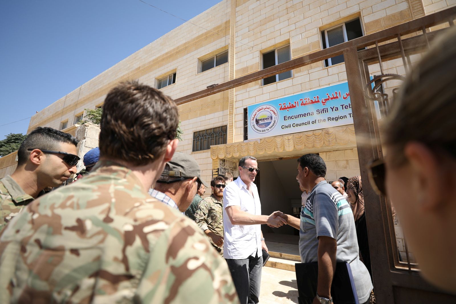 Brett McGurk, U.S. envoy to the coalition against Islamic State, shakes hands with a man in the town of Tabqa - REUTERS