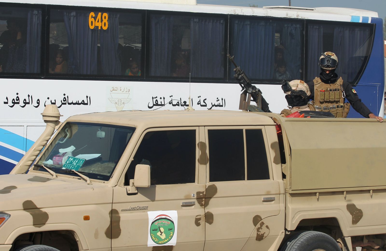 قوات عراقية تُشرف على عملية نقل النازحين من مخيم الحبانية - AFP