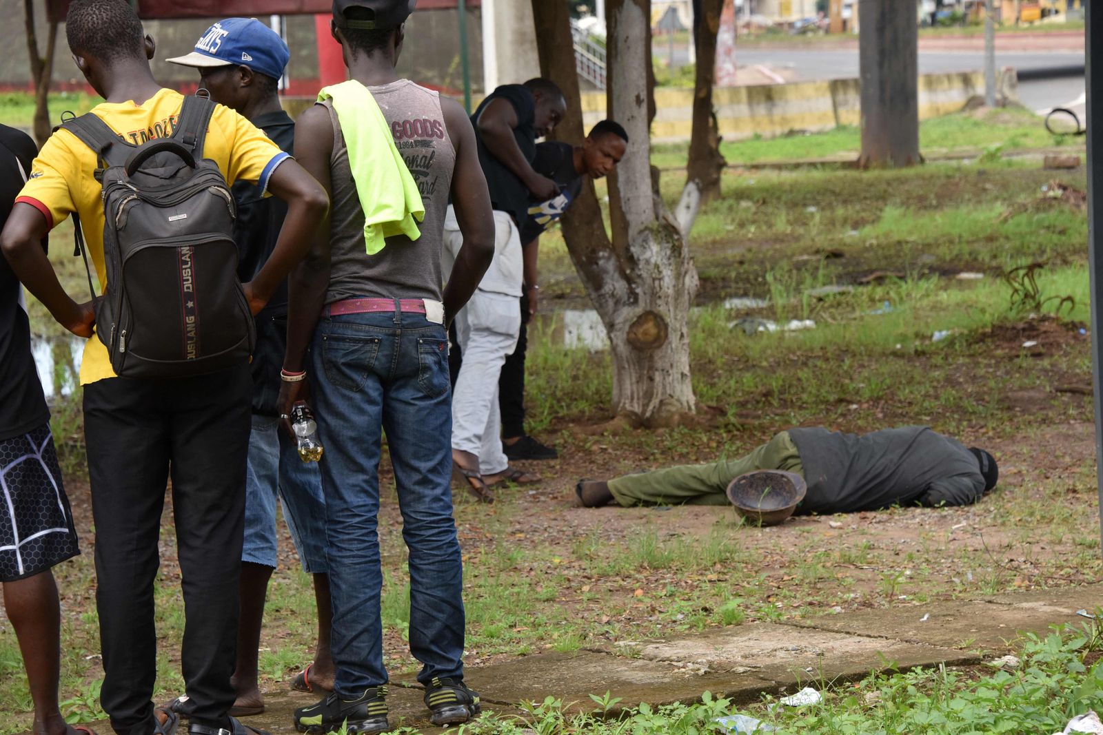 People look on at a corpse in the central neighbourhood of Kaloum in Conakry on September 5, 2021 after sustainable gunfire was heard. - Gunfire was heard in Conkary in the morning and troops were seen on the streets, witnesses told AFP. There was no immediate explanation for the incidents in Conakry's Kaloum peninsula, where the presidency, various institutions and offices are located. (Photo by CELLOU BINANI / AFP) - AFP