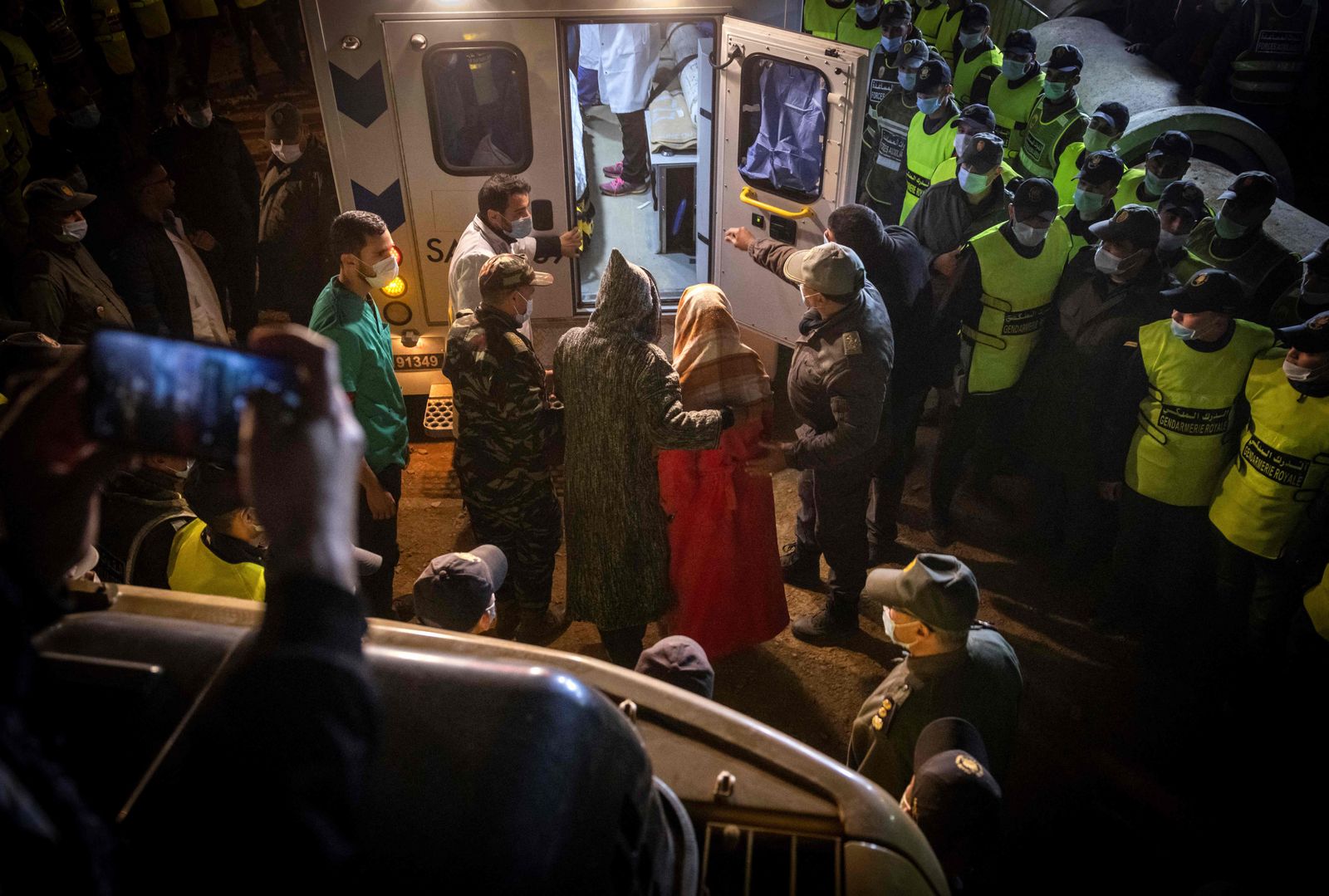The parents of Rayan look inside an ambulance at the site of where his body was pulled out from a well shaft where he had fallen into on February 1, in the remote village of Ighrane, in the rural northern province of Chefchaouen on February 5, 2022. (Photo by FADEL SENNA / AFP) - AFP