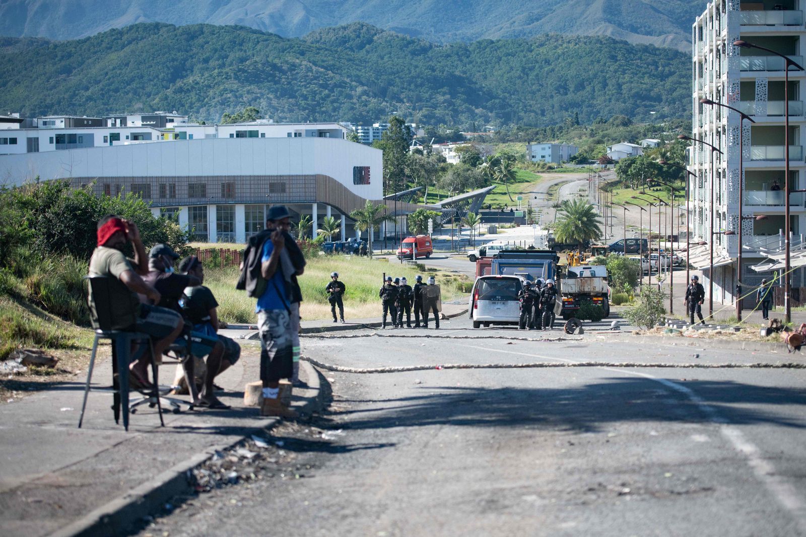 French gendarmes face pro-independence protesters as clashes occur during the removal of a roadblock on Paul-Emile Victor avenue in Dumbea on the French Pacific territory of New Caledonia on June 24, 2024. Clashes started after even independence activists linked to a group accused of orchestrating deadly riots last month in New Caledonia have been sent to mainland France for pre-trial detention. Riots, street barricades and looting broke out in New Caledonia in May over an electoral reform that would have allowed long-term residents to participate in local polls. (Photo by Delphine Mayeur / AFP)